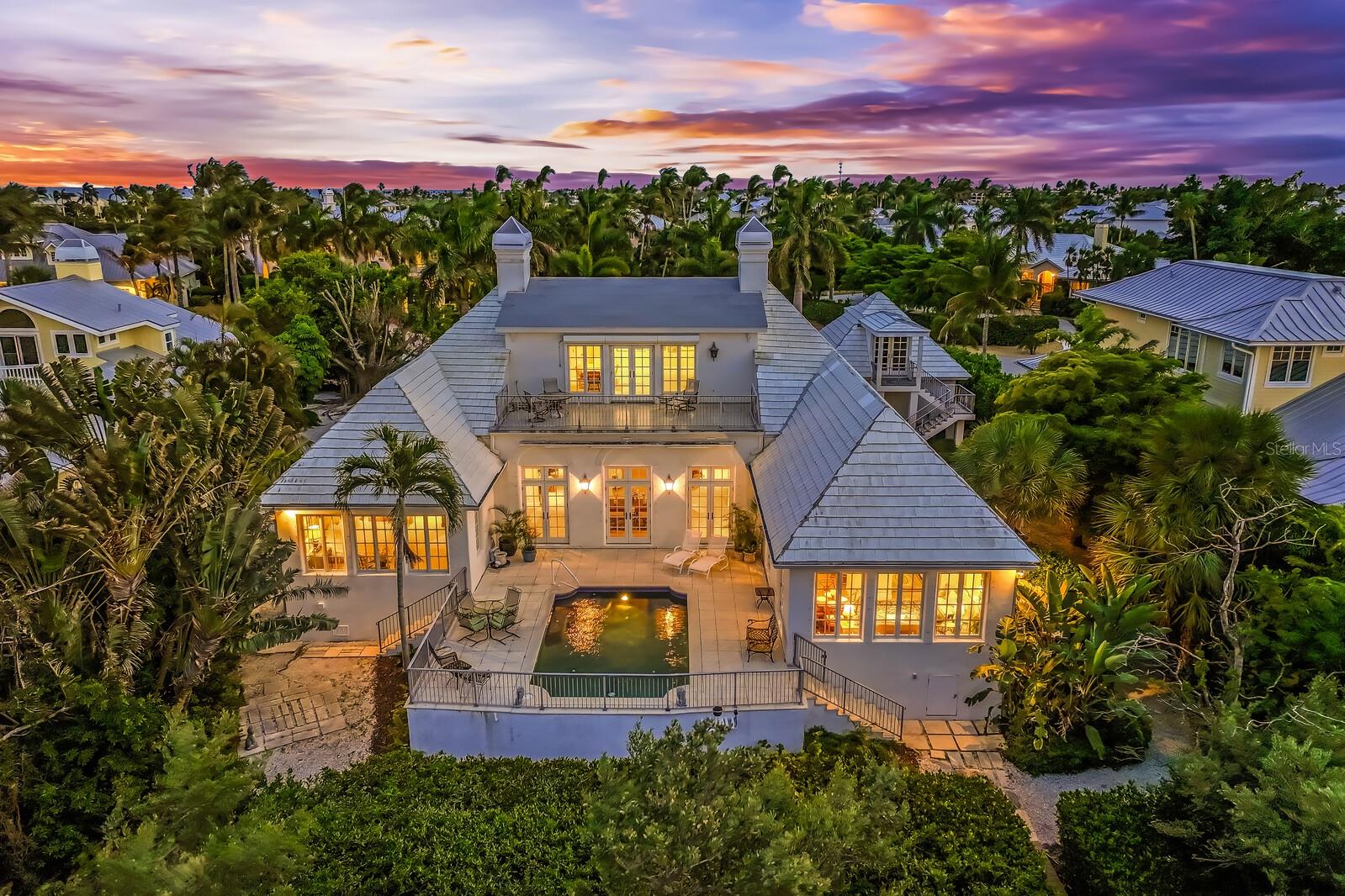 Located in the Beautiful Boca Grande Isles, 1669 Jose Gaspar Drive is a striking example of Bermuda-style architecture, seamlessly blending timeless elegance with relaxed coastal living. Constructed of solid concrete with a durable concrete tile roof, the home features a classic stucco exterior and signature stepped rooflines—designed for both aesthetic appeal and resilience—capturing the essence of refined island design.
Inside, light-filled interiors create an airy, sophisticated atmosphere. Expansive living spaces flow effortlessly, offering the perfect setting for both entertaining and everyday comfort. Thoughtful architectural details and curated finishes evoke understated luxury, while French doors and large windows and open layouts invite in natural light and gentle harbor breezes.
Spanning approximately 4,500 square feet, the home features a gourmet kitchen complete with a sitting and casual dining area, along with a spacious great room anchored by a stunning shell stone fireplace—ideal for gatherings. The residence includes five bedrooms and six and a half baths, many with serene harbor views. An unfinished bonus room above the garage provides flexibility for a home office, studio, or additional bedroom.
Outdoors, a beautifully elevated pool and patio create a private oasis, perfectly complementing the home’s stately presence within the Boca Grande Isles. Surrounded by lush tropical landscaping and some of the island’s finest fishing, the property offers a private retreat just moments from Boca Grande’s pristine beaches, charming village center, and scenic bike paths.
This exceptional Bermuda-style residence embodies coastal sophistication and island luxury—an outstanding opportunity to experience the beauty and serenity of Boca Grande living.