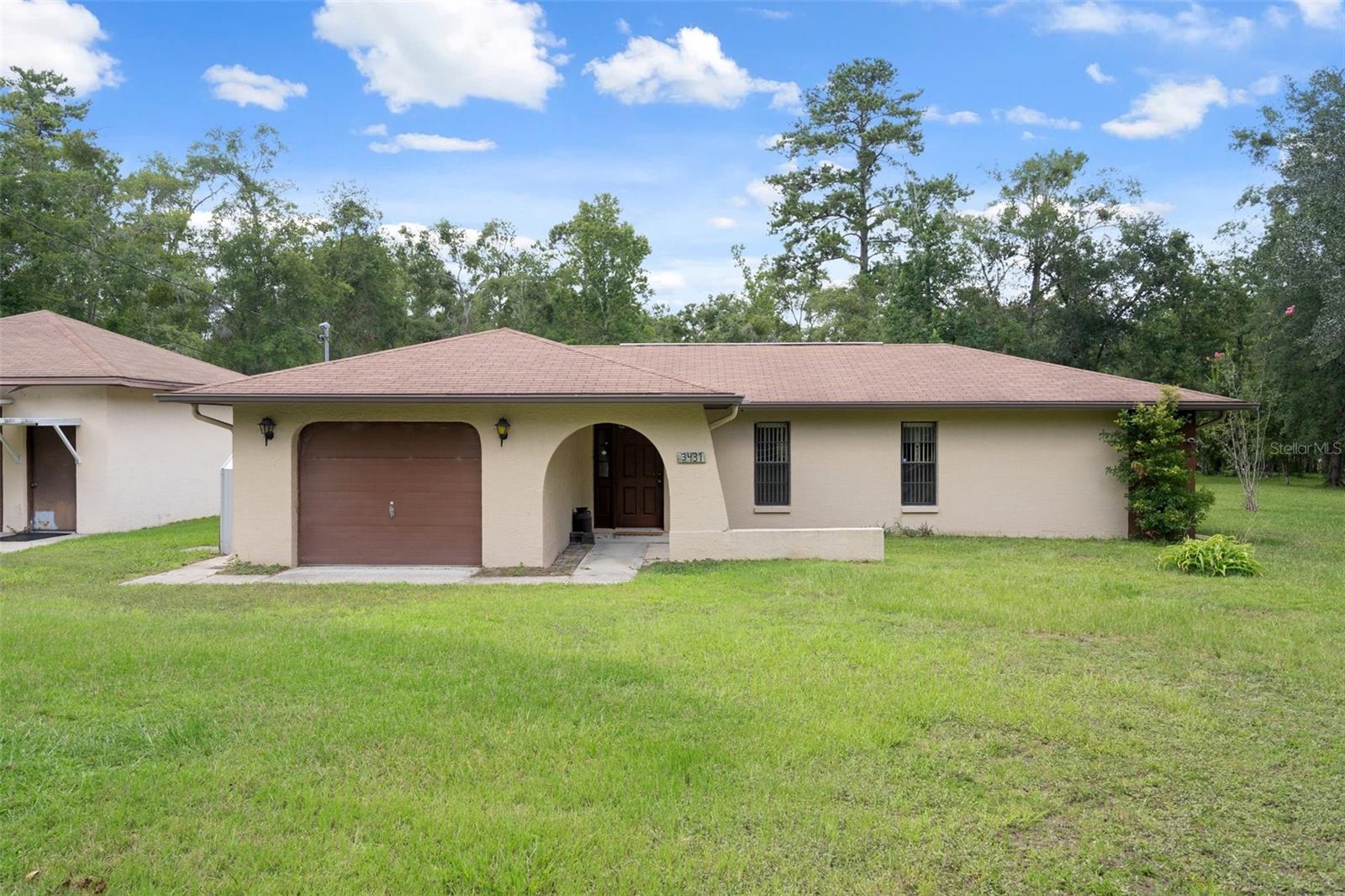 Welcome to 3431 Rackley Rd! Discover the opportunity to create your own retreat on this fully fenced 2.8-acre property in a peaceful Brooksville setting. This 2 bedroom, 2 bathroom home offers a solid foundation with a functional layout and attached 1-car garage. It’s ready for your updates and personal vision. Outside, the possibilities truly open up—whether you're dreaming of space for animals, a workshop, or simply more room to breathe. The detached 2-car garage and additional carport provide ample flexibility for storage, hobbies, or equipment. The land is usable, private, and full of potential. No HOA, no restrictions—just a quiet setting and a property that lets you design the lifestyle you’ve been looking for. This is more than a home—it’s a chance to build the kind of life that fits you.