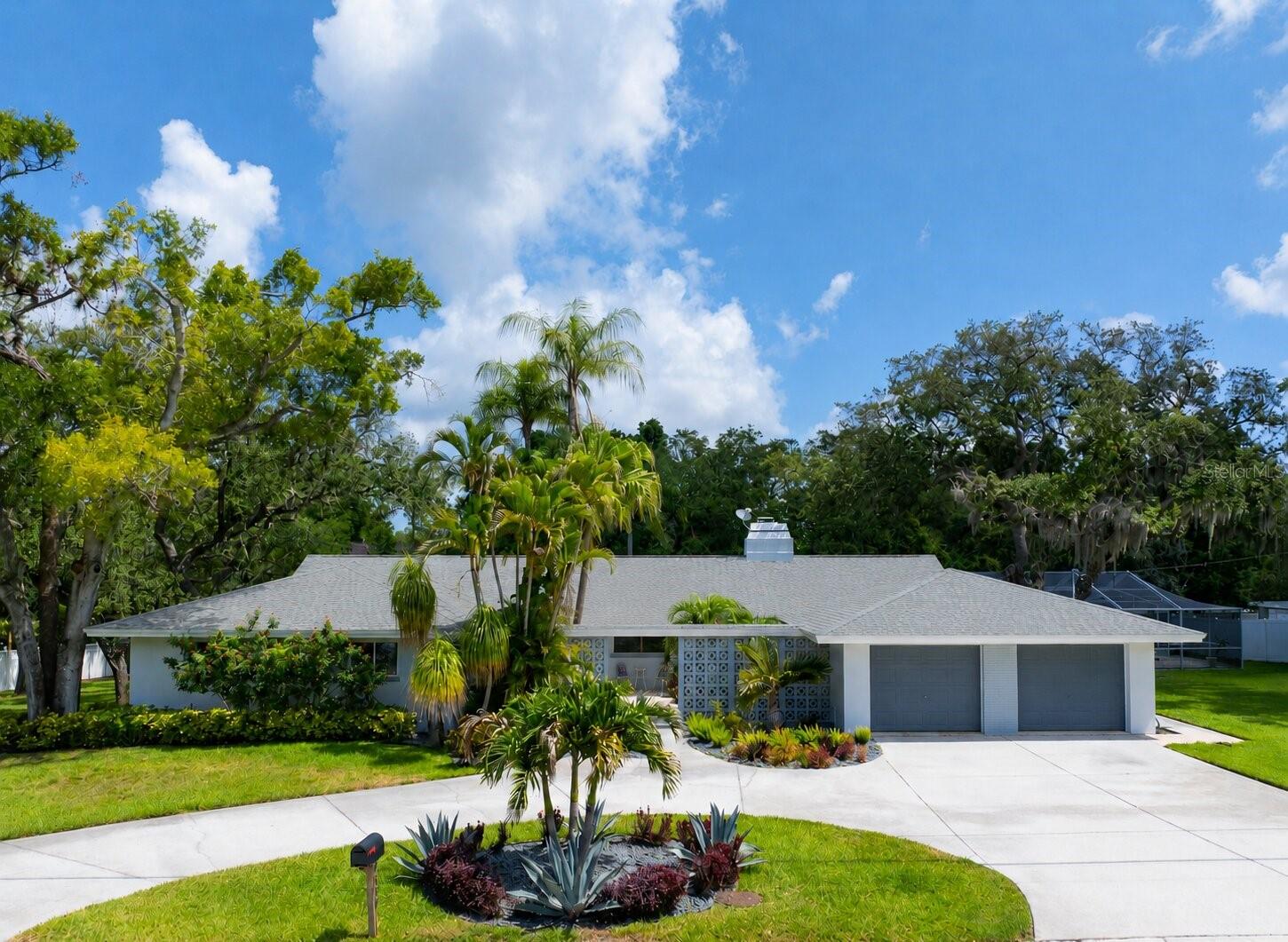 Welcome home to a rare opportunity in Fairway Estates. Beautifully updated and situated on a rare 0.45-acre double lot, this 5-bedroom, 3-bath pool home offers 3,384 Sq Ft of thoughtfully designed living space with room to spread out both inside and out. Properties with this much usable yard space are seldom available, offering privacy, flexibility, and endless possibilities for outdoor living. Surrounded by mature trees and tropical landscaping, this home provides a peaceful setting while remaining close to everything you need. A private courtyard welcomes you to the front entrance. Inside, the spacious floor plan flows naturally from the living and dining rooms into the heart of the home, a large family room featuring a beautiful wood-burning fireplace with a travertine marble surround, creating a warm and inviting space for family gatherings or quiet evenings at home. The renovated kitchen blends style and function with custom wood cabinetry, granite countertops, double ovens, generous counter space, a breakfast area, and a movable granite-top island that's perfect for entertaining. Travertine marble flooring extends through the kitchen and dining room, while upgraded wood-look porcelain tile adds a fresh, modern feel to the living room and bonus room. The bonus room provides flexible space for a home office, playroom, fitness room, or media room. One of the home's standout features is the impressive 40-foot Florida room, creating an incredible extension of the living space with beautiful views of the screened pool and backyard. With multiple living and gathering areas throughout the home, there's plenty of space for everyone to spread out while still coming together for holidays, celebrations, and everyday life. At the end of the day, retreat to the oversized primary suite, thoughtfully updated with new porcelain tile flooring and a beautifully renovated en-suite bathroom featuring a double-sink vanity, designer finishes, and a spacious walk-in shower. Four additional bedrooms and three full bathrooms provide flexibility for growing families, guests, or multigenerational living. Step outside and enjoy your own backyard retreat. The covered screened lanai opens to a spacious screened pool enclosure, creating the perfect setting for relaxing or entertaining throughout the year. Situated on a rare double lot, the property offers an expansive side yard with the potential for boat or RV parking—an uncommon feature in this neighborhood. Whether you need extra space for your recreational vehicles, outdoor hobbies, pets, or simply want room to spread out, this property offers flexibility that's hard to find. Additional updates provide peace of mind, with a Fully renovated primary bathroom (2026), upgraded energy-efficient windows, fresh exterior paint (2026), upgraded 24-inch vinyl soffits, a new HVAC system with all-new ductwork and variable-speed air handler (2023), and new pool equipment (2023). Only minutes from Dunedin Golf Club, Downtown Dunedin, Dunedin Causeway & Honeymoon Island, Restaurants, Hospitals, Shopping and more. Whether you're looking for room to entertain, space for a growing family, or simply a property with features that are becoming harder to find, this Fairway Estates home offers an exceptional opportunity to make it your own. No Flood Zone