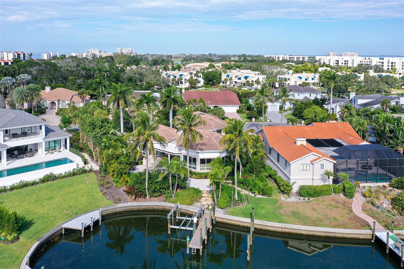 A Waterfront Work of Art. Experience a one-of-a-kind waterfront residence on Longboat Key — now offered at an exceptional new value. Designed around three interconnected circular "pods," the residence flows like a choreographed dance. There are no awkward hallways, no wasted corners, no spaces that feel like afterthoughts. Curved walls carry throughout every room — even into the garage — creating a cohesive design statement that's genuinely rare in residential construction at any price point. This architectural masterpiece is a sculptural composition of flowing living spaces connected by custom corridors, delivering remarkable privacy, abundant natural light, and seamless indoor–outdoor living.

The dramatic Great Room pod showcases soaring wood-paneled ceilings and expansive walls of glass that frame tranquil water views. The circular primary suite is a private retreat featuring a spa-inspired bath with dual showers, a lounge area, private office, and direct access to the pool and spa terrace.

At the heart of the home, the striking circular kitchen is both artful and functional, centered around a curved island beneath a two-story ceiling and skylight, with a thoughtfully designed radial appliance layout. Two en-suite guest bedrooms open to private patios, while the fully self-contained Secondary Primary Suite above the impressive 32' x 23' three-car garage offers independent HVAC, a luxury bath with steam shower and sauna, and flexible living space ideal for extended guests or multigenerational living.

Outdoors, the property embraces the waterfront lifestyle with protected deep sailboat water, a private dock with a 12,000-pound lift, and a resort-style pool and spa designed for entertaining and relaxation. Located behind the 24-hour guarded gates of Bay Isles, residents also enjoy exclusive access to the Bay Isles Beach Club on the Gulf of Mexico.