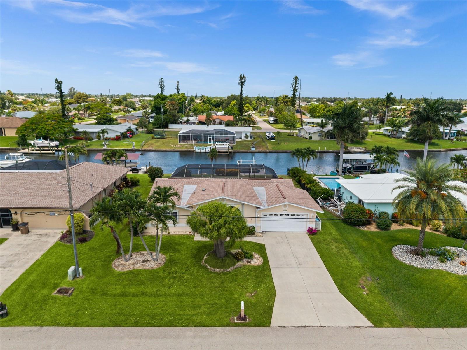 AFFORDABLE GULF ACCESS WATERFRONT POOL HOME ON CAPE CORAL’S FAMOUS 100' WIDE SAN CARLOS CANAL! Ideally located in SE Cape Coral near downtown restaurants, shopping, and conveniences, this 3-bedroom, 2-bath pool home offers 1,614 square feet of living space, a 2-car garage, and QUICK BOATING ACCESS to open water. Mature tropical landscaping welcomes you home, while the backyard is designed for enjoying the Southwest Florida lifestyle with a screened pool, paver pool deck, large covered lanai, and both concrete and wood dock areas along the canal. Inside, the home offers an open, functional layout with plenty of sliding doors bringing natural light and pool views into the main living spaces. The kitchen features lots of cabinets, a center island, and convenient access to the enclosed sunroom, creating additional flexible space for dining, relaxing, or entertaining. The dining area includes built-in shelving, while the interior laundry closet includes a washer and dryer. The primary bathroom also serves as a pool bath, with direct access to the lanai and pool area. ROOF 2021. Whether you are looking for a full-time waterfront residence, vacation home, or investment opportunity, this is a great chance to own Gulf access waterfront in a convenient SE Cape Coral location.