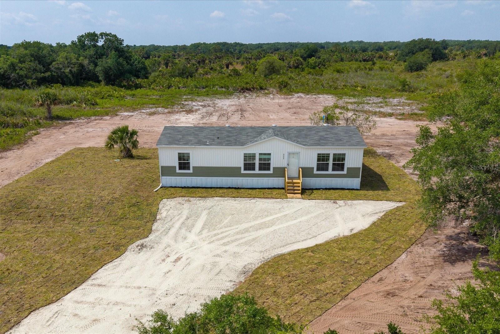 Don’t miss this opportunity to own a brand-new 2026 factory-built Summit model offering modern design, quality craftsmanship, and peaceful country living in the sought-after Prairie/Viking area of Okeechobee.
This beautifully designed home features 3 bedrooms, 2 bathrooms, and 1,369 sq ft of open-concept living space, perfectly laid out for both everyday comfort and entertaining. The split floor plan provides privacy, with a spacious primary suite separate from the guest bedrooms.
Step inside and enjoy upscale finishes throughout, including tray ceilings, crown molding, an upgraded lighting and ceiling fan package, and a bright, airy layout. The kitchen is the heart of the home, complete with a large island, stainless steel appliances, and seamless flow into the family and dining areas.
The primary suite is a true retreat, featuring a large walk-in closet, double vanity, soaking tub, and an upgraded walk-in shower. 
Set on a gorgeous 1.25-acre AG-zoned lot, this property offers endless possibilities—bring your animals, RVs, boats, and more. There’s ample room to add a barn, workshop, garage, or pool while still enjoying wide-open space and privacy.
Additional highlights include:
• Two-toned exterior with horizontal lap and board-and-batten siding
• Sliding glass doors to the backyard
• Interior laundry room with exterior access
• Well, septic, water filtration system, and full setup included
• Turn-key and move-in ready
Conveniently located just a few blocks off main roads for easy access, while still offering a quiet, rural feel. This stunning home comes complete with well, well equipment, septic, steps, skirting, sod, AC, electric, and turn-key for buyer to move right in.
Multiple homes available in the Prairie/Viking area, including move-in ready options and homes nearing completion (30–90 days).
Schedule your showing today and experience the space, freedom, and value this property offers.