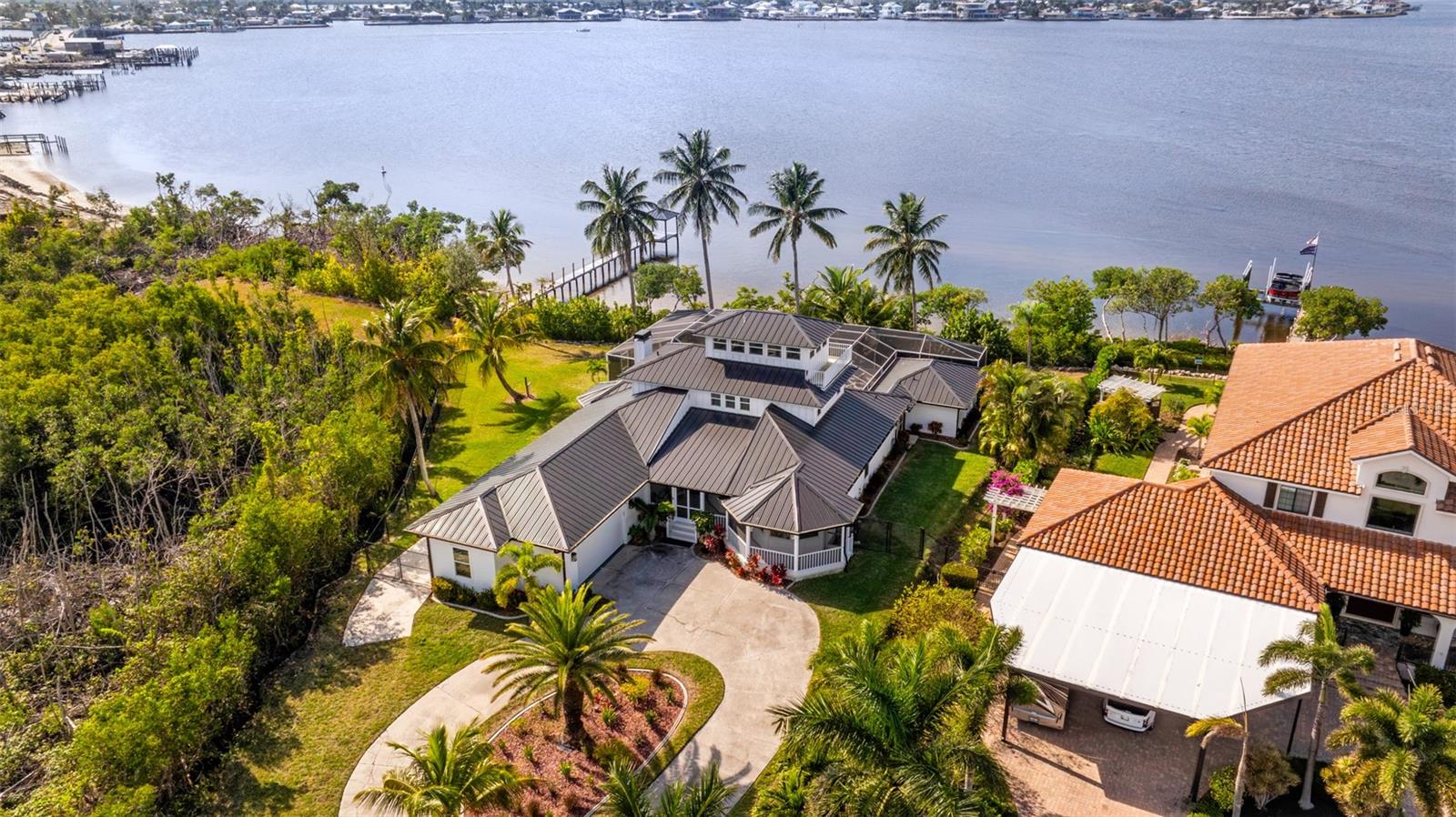 Stunning waterfront estate set on 2.24 acres in the heart of Matlacha—truly a boater’s paradise just minutes from some of Florida’s finest boating, including Boca Grande and Sanibel. This turnkey 4,021 sq ft residence offers 5 bedrooms, 4.5 baths, and a third-floor den with breathtaking 360° views of Pine Island and the surrounding bay, with water views gracing nearly every room. The fully updated interior showcases a custom kitchen, granite countertops, state-of-the-art appliances, new impact windows and doors (2023), and a charming wood-burning fireplace. Poolside, a detached guest suite provides a spacious private retreat with a full bath—ideal for guests, in-laws, or extended stays. The exterior is equally as impressive, featuring an expansive screened lanai, with a large pool and spa, overlooking the bay. This home has had a number of upgrades, including a new aluminum metal roof, hardie board siding, professional lighting, a new irrigation system and a new fence in 2025. For the boaters, this house includes a new covered metal roof 10,000 lb. boat lift, making those trips to Boca Grande and Sanibel a breeze. The house also features a spacious 4 car garage, and a large slab for a boat or RV. This house sits extremely high, and has never flooded during any hurricanes! Offered fully furnished and turnkey, this exceptional property makes living the Florida waterfront dream as effortless as it is extraordinary.