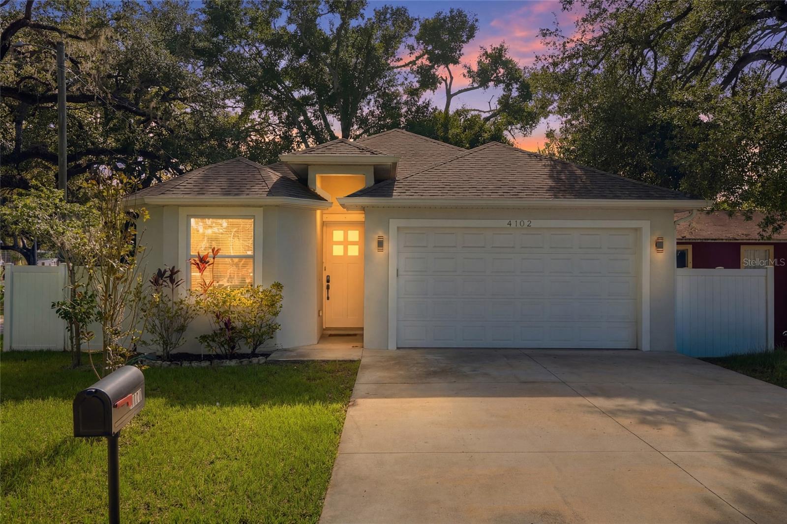 Excellent buying opportunity! Built in 2022 and meticulously maintained, this custom built three bedroom, two bath home with a two car garage combines thoughtful design with modern comfort in a location that keeps you close to everything Tampa has to offer. Step inside to an inviting open floor plan enhanced by beautiful luxury laminate flooring throughout, a desirable split bedroom layout and an abundance of natural light. At the heart of the home, the gourmet kitchen features custom designed white cabinetry, granite countertops, stainless steel appliances, and a seamless connection to the family room, creating a comfortable space for everyday living and entertaining. The spacious primary suite offers a private retreat with dual vanities, quality finishes, and an oversized walk-in closet. A well-appointed laundry room with a utility sink adds everyday convenience. French doors from the living room to a covered porch and adjoining brick paver patio, extending the living space outdoors and providing an ideal setting for relaxing or outdoor entertaining. The fully fenced backyard with durable PVC fencing is shaded by mature oak trees, creating a peaceful outdoor environment.  Conveniently located with quick access to many of Tampa's most popular destinations, including Water Street, Armature Works, Seminole Heights, ZooTampa, Tampa International Airport, and International Plaza, all within approximately 10 to 15 minutes. This is an exceptional opportunity to enjoy the convenience of a newer custom home in a highly accessible Tampa location. Come see this amazing home today and make it yours tomorrow!