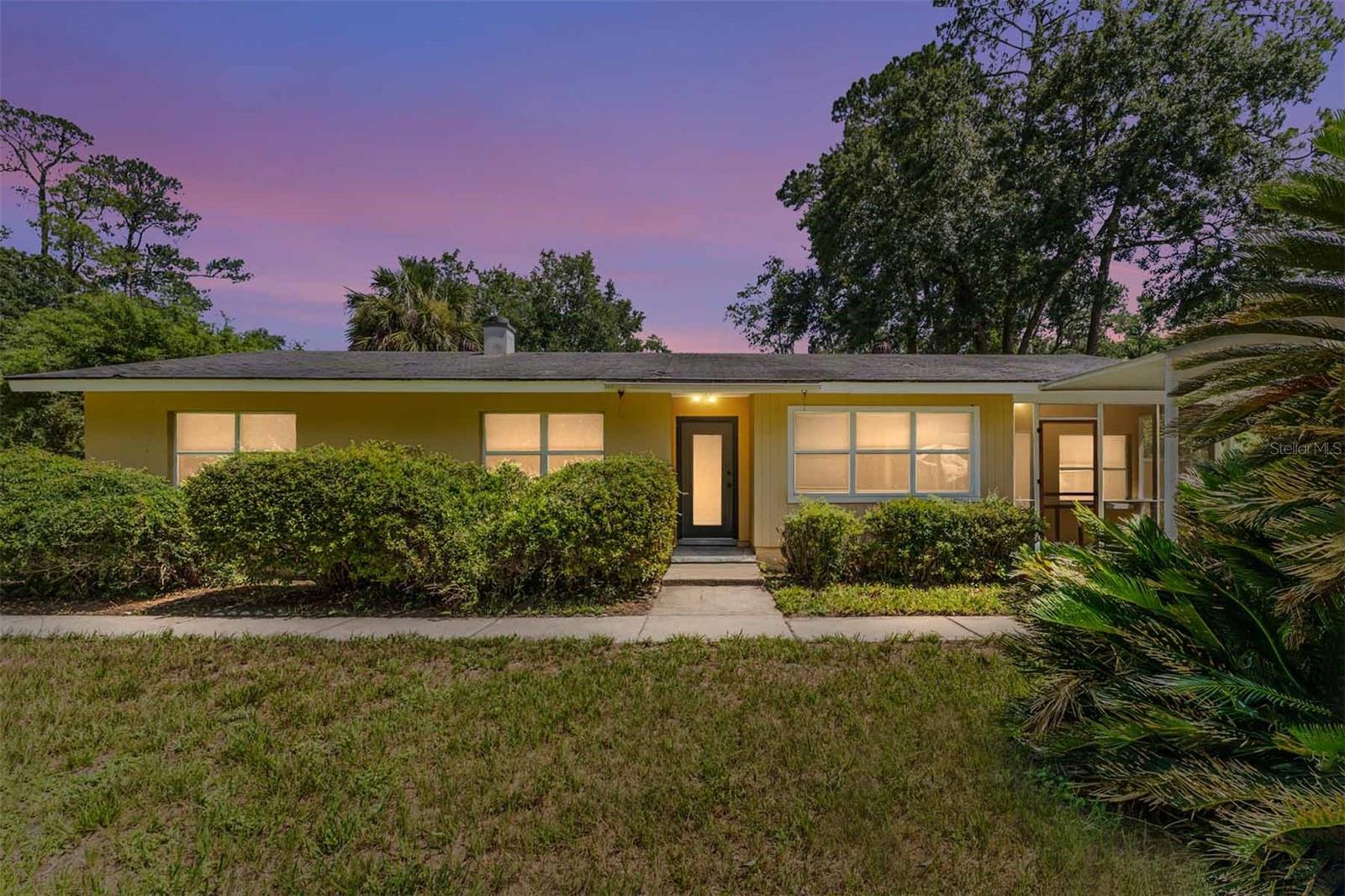 Virtually Staged. Welcome Home to Highland Court This updated 4-bedroom, 2-bath ranch offers 1,467 square feet of living space on a .33-acre lot. Step through the front door into a spacious living and dining room combination. Enjoy an updated kitchen featuring granite countertops.
Just off the living room, a step down leads to a versatile bonus room, perfect as a 4th bedroom, craft room or home office. This flexible space has its own separate entrance and a private screened porch, which opens out to the double driveway and carport. Down the hall you'll find three additional bedrooms, each with built-in closets and drawers. The primary bedroom has a fully renovated bathroom with a tub/shower combo, while the updated hall bathroom features a walk-in shower.  The kitchen's back door leads to an enclosed laundry area with a utility sink, opening onto an oversized backyard, your own private retreat. Relax in the 17x17 screened patio or bring your green thumb to the designated area perfect for a greenhouse. Three storage sheds offer plenty of room for tools, equipment, or hobbies.  This expansive lot is ready for you to make it your own, with plenty of space to build an ADU complete with its own driveway, entrance and patio.  Ideal for multigenerational living or rental income potential. Located in a desirable neighborhood, you're within walking distance to Public & General, and just a quick bike ride to downtown. Easy access to UF.