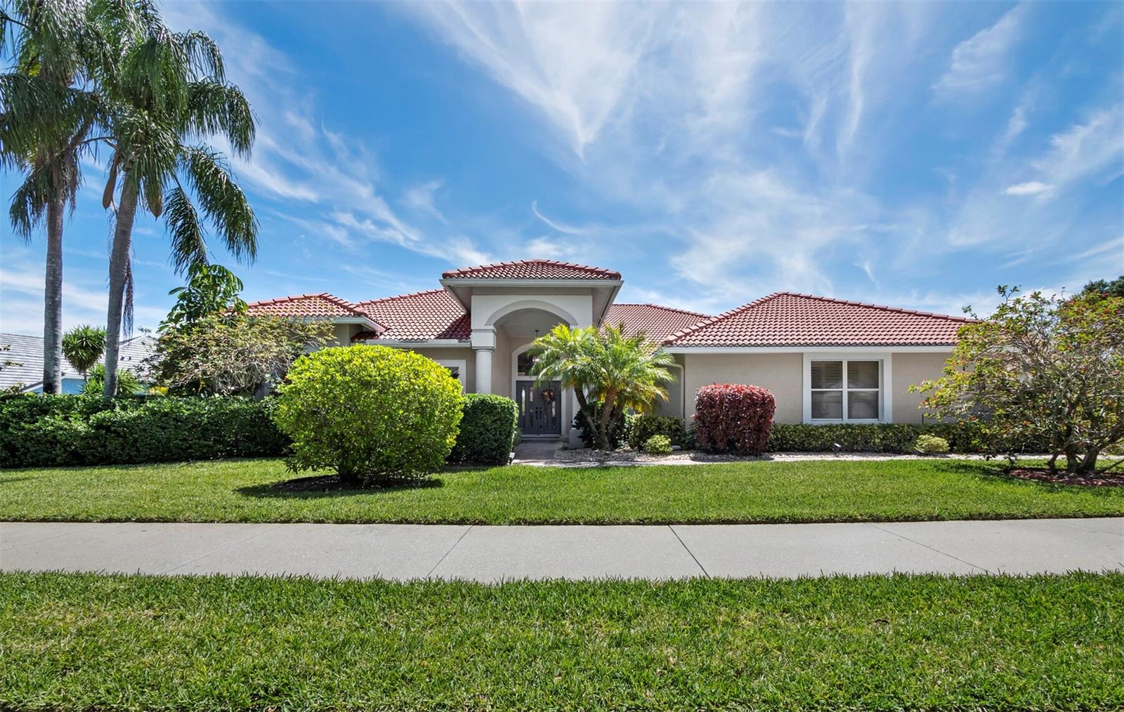 Prepare to be captivated by sweeping long lake views that immediately set a tone of serenity and Florida beauty. From the moment you step inside, the home frames this stunning backdrop through expansive glass sliders, drawing your eye straight to the sparkling pool, caged lanai, and the tranquil water beyond. Set gracefully on an oversized lot, this three-bedroom residence with an office/den, offers a flexible and spacious floor plan. A gracious foyer opens to an expansive living space creating a seamless connection between the indoor and outdoor living with serene, picturesque views. The home offers effortless entertaining from the formal dining room to the open kitchen, which showcases abundant cabinetry, generous counter space, a breakfast bar, cooking island, ceiling details, and eating space. Ideally positioned beside an aquarium window, the casual eating area captures tranquil views of the pool and stunning long lake beyond. The gracious family room is anchored by a wood-burning fireplace and sliding doors, all set against the serene backdrop. The large primary suite is a private retreat featuring direct access to the pool area, a spacious walk-in closet, and a well-appointed bathroom with dual vanities, walk-in shower and soaking tub.  The open floor plan is sequenced perfectly with a split design offering two guest suites, two additional full baths, ensuring privacy for family and visitors alike. Additional highlights include decorative front doors, plantation shutters, high ceilings, built-in features, storage throughout, and an oversized side-entry three-car garage. The seller is under contract to replace the roof at seller’s expense. Deer Creek is a premier 285-acre gated community nestled in the heart of Palmer Ranch. Surrounded by mature foliage, and abundant nature preserves, ideal for those seeking an active, yet tranquil lifestyle. Deer Creek’s desirable location is near the award-winning Legacy Trail, top-rated championship golf courses, top schools, gourmet restaurants and a short drive to Siesta Key Beach. This is Florida living at its finest - schedule your private showing today!