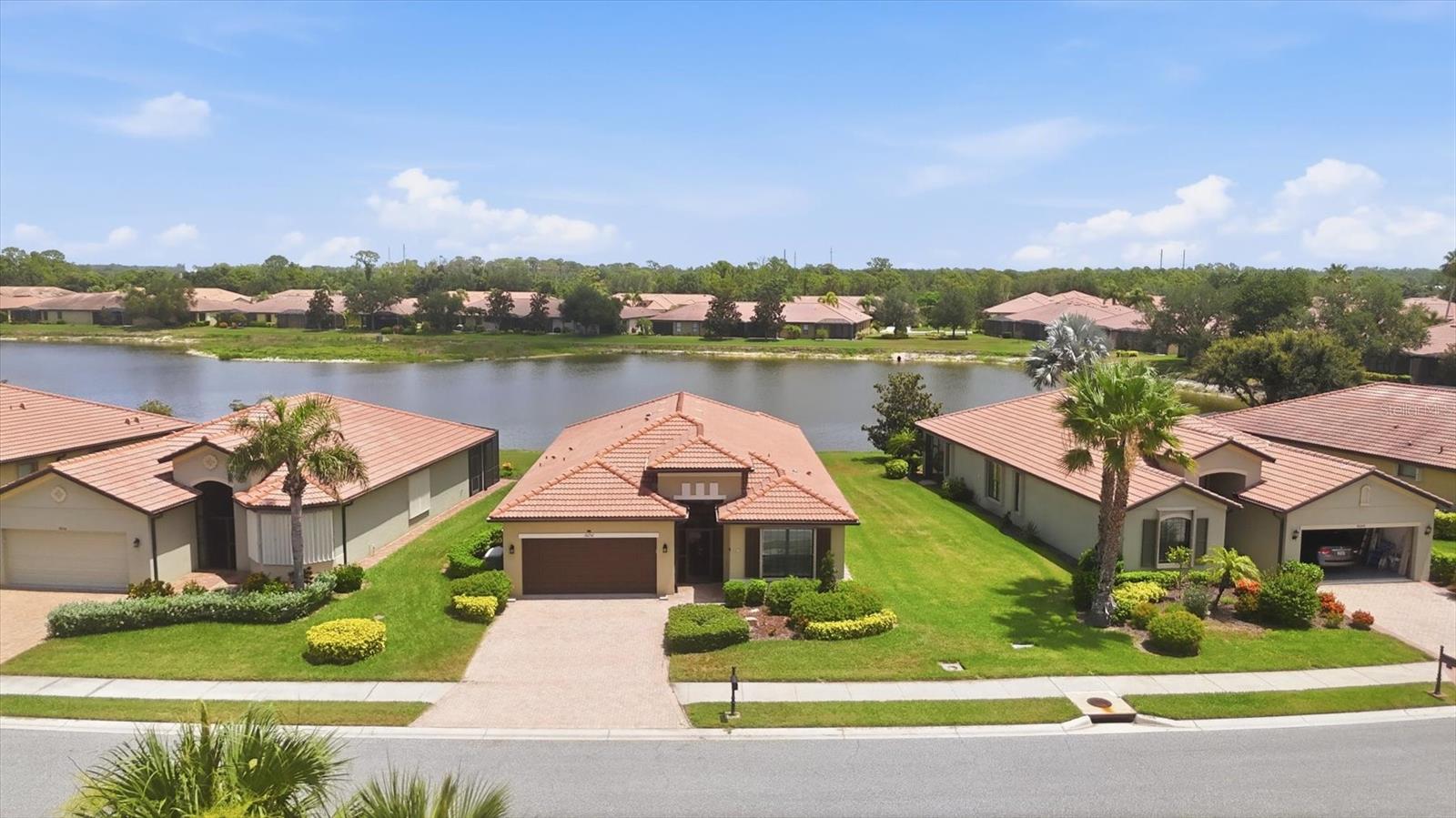 Welcome to your private lakeside retreat within the well-regarded 55+ gated community of Venetian Falls. Enjoy tranquil water views from this meticulously maintained 2-bedroom, 2-bath home with a spacious den. The bright, coastal-inspired living space features soothing tones, tray-ceilings with crown molding, timeless quartz countertops and vanities, plus all hardwood and tile flooring throughout. To complement the abundance of upgrades, the home is completely hurricane-protected with accordion shutters and equipped with a 2021 fully automatic 20KW Kohler Generator with 500-gallon fuel tank for added convenience and easy Florida living.
The fully remodeled kitchen showcases newer appliances, reverse osmosis water purification, and a sparkling breakfast bar with updated cabinetry, while the designated dining room plus dinette offers versatility for gatherings. The primary suite features two large closets, lanai access glass-sliders, and en-suite bath with dual sinks and a tile walk-in shower. Enjoy plentiful storage in every closet with custom built-in shelving, and a murphy bed in the second bedroom.
Step outside to the private screened lanai with custom landscaping, stone pavers, and picturesque water views perfect for quiet morning relaxation or entertaining guests. Additional highlights include a 2020 HVAC, a dedicated laundry room, whole home water softener, and an epoxy-coated garage floor with custom storage. 
Venetian Falls offers resort-style amenities with a clubhouse, pool, fitness center, billiards room, putting green, bocce courts, and more. The low fee also includes lawn care, irrigation, roof cleaning, and cable and internet, that makes living here a breeze so you can simply enjoy the laid-back Florida lifestyle you've been waiting for.