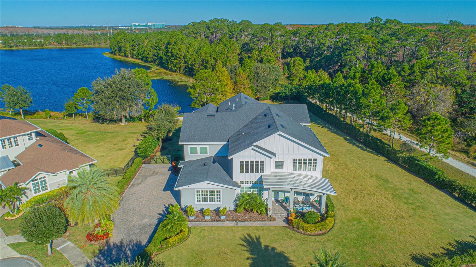Under contract-accepting backup offers. Welcome to the epitome of refined living – a true architectural marvel seamlessly blending luxury, comfort, and entertainment against the backdrop of breathtaking water views within the gates of the Preserve at Laureate Park. This enchanting two-story residence, spanning 5,536 sq.ft., encompasses FIVE bedrooms and SIX and ONE HALF bathrooms, delivering an unparalleled fusion of space and sophistication. Built on a sprawling .61 acre lot on a private cul-de-sac this masterpiece offers upgrades and panoramic views from every room. Upon crossing the threshold, the first-floor living spaces captivate with exquisite porcelain tile flooring, setting the stage for an interior designed with meticulous attention to detail. The kitchen, a haven for culinary enthusiasts, is adorned with granite countertops and premium finishes that redefine the heart of the home. The seamless transition from room to room is guided by the brilliance of shining tiled flooring, while two-story ceilings with strategically positioned windows invite an abundance of natural light, creating an atmosphere of warmth and openness. Explore the intelligently designed spaces, revealing a purposeful home office, a formal living room seamlessly connected to a formal dining room, and a chef's dream kitchen. The culinary haven features an island, granite counters, a stylish tile backsplash, a built-in convection oven, microwave, gas grill cooktop, pantry, and upgraded stainless steel appliances. The dining and breakfast dinette effortlessly connect to the kitchen, facilitating the serving of meals with ease. The spacious family room, featuring a gas fireplace, provides a touch of coziness, while the two primary suites, including one on the first level, offer flexibility for accommodating in-laws or guests. The en-suites are a testament to luxury, featuring stone-tiled surround soaking tubs, walk-through showers behind designer walls, split double sink vanities, and ample cabinet space. Practicality meets luxury with designer walk-in closets. Ascend to the second floor, accessed via two separate wood tread staircases, to unveil a grand bonus room customizable as a media room, game room, or additional family space. French doors open to a covered balcony, extending the living space and offering panoramic water views. Four additional bedrooms, including the second-floor primary with an amazing window wall gives a magical view of the lake in particular at sunrise and sunset. The artificial fireplace gives a cozy feel on cooler winter nights plus sun-reflecting foils on large windows provide UV and temperature control. The interior aesthetic is curated with a clean and classic color palette, creating a warm and inviting ambiance. Technological enhancements include a central Sonos sound system with six zones, each app-controlled, and strategically placed ceiling speakers.Transitioning to the exterior, the expansive backyard beckons relaxation and entertainment. The homeowner's vision materializes with a salt water pool and spa, expansive decking, water and fire features, a poolside seating area with a fire pit, a covered patio with built-in summer kitchen and remote-controlled screens. The freeform pool design optimizes space, leaving open green areas for pets and family to enjoy. A privacy hedge encloses the backyard to enjoy the stunning lake views.The three-car garage is not just utilitarian but a storage marvel with custom cabinets. Make your appointment to see today!