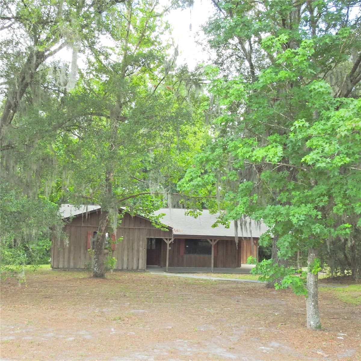 Discover the perfect blend of privacy, space, and country charm at 22154 Powell Road. Situated on approximately 2.02 acres, this 2-bedroom, 2-bath home offers a peaceful setting surrounded by mature trees and natural Florida beauty.
A welcoming porch sets the tone for relaxed outdoor living, while the interior features tile flooring throughout, a spacious kitchen with abundant cabinetry, a center island, and a dining area with access to the screened porch. The living room showcases a wood-burning fireplace, creating a comfortable gathering space for family and friends.
The primary suite includes a walk-in closet, private bathroom, and direct access to the porch, providing a quiet place to enjoy the surrounding landscape. The expansive property offers plenty of room for outdoor activities, gardening, recreational vehicles, or future improvements, subject to local regulations and approvals.
Conveniently located with access to Brooksville, major roadways, shopping, dining, and everyday amenities, this property provides the opportunity to enjoy a more relaxed lifestyle without sacrificing accessibility. Schedule your private showing today and explore all that this unique property has to offer.
