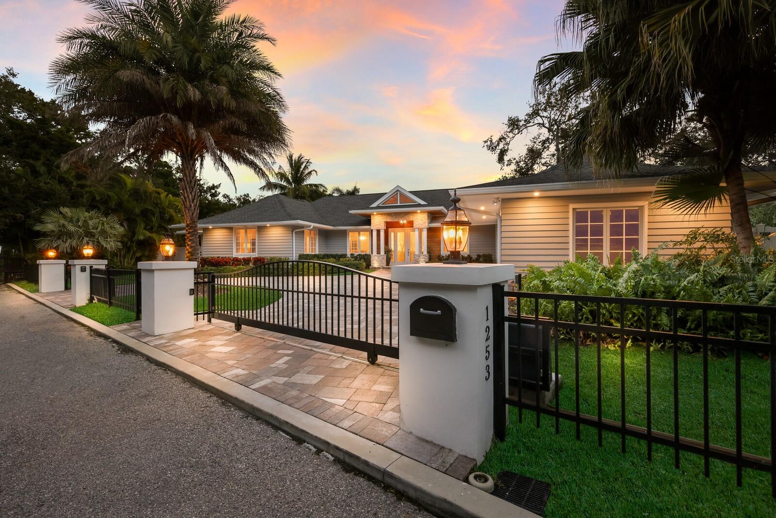 One or more photo(s) has been virtually staged. This exquisitely reimagined waterfront estate embodies modern luxury and serene exclusivity, offering 174 feet of prime waterfrontage in the prestigious Sanderling Club on Siesta Key. On a lush, nearly half-acre parcel, the residence enjoys a southern orientation, where panoramic views of a bridgeless bay unfold through walls of glass. A backdrop of meticulously landscaped greenery ensures privacy, all just near the water’s edge. At the heart of the home lies a state-of-the-art culinary haven. The chef’s kitchen is equipped with premium Wolf and Sub-Zero appliances, including a gas range and integrated espresso system, set within rich Merillat solid-wood cabinetry and dual islands designed for function and entertaining. Flowing seamlessly into the sunlit living and dining areas, the open-plan design creates an effortless connection between indoors and out. The living space extends gracefully to a sophisticated entertainment patio, where a firelit lounge, sparkling pool and fully appointed outdoor kitchen echo the refinement found within. The primary suite offers a tranquil retreat, framed by a garden and oak vista, and complemented by a spa-inspired bath featuring a deep soaking tub, dual vanities, and indoor and outdoor showers. An adjoining office doubles as a guest suite, while additional en-suite accommodations ensure privacy and comfort for visitors. Modern conveniences and peace of mind abound such as remote-controlled wrought-iron gates, impact-resistant windows and doors, whole-house water treatment, advanced smart-home systems, new roof, backup generator and environmentally conscious amenities, including a 500-gallon propane supply and integrated mosquito-repellent system. As a resident of Sanderling Club, you’ll enjoy access to a private beach, boat slips, tennis courts, clubhouse and 24-hour security, an unrivaled blend of leisure, privacy and coastal sophistication. This residence has been meticulously curated for those who seek the ultimate fusion of luxury and tranquility, an invitation to a lifestyle defined by elegance, ease and timeless waterfront living.