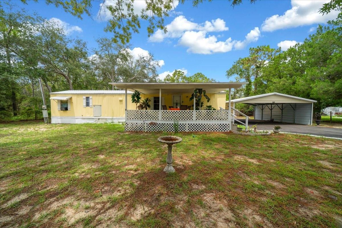 Virtually Staged. Welcome to this charming 2-bedroom, 1.5-bath single wide bursting with Florida character! Featuring a brand-new roof in 2025 & also a new refrigerator. This cheerful yellow home sits on a large lot with plenty of space to add your dream pool. Great for full-time living or a relaxing getaway, it offers an inviting front porch for morning coffee and a back porch with an oversized deck for entertaining or enjoying the sunshine. Laundry hook-ups are conveniently located on the back porch for easy access. The spacious yard provides endless possibilities—create a garden, add a pool, or simply enjoy the open space. Located just minutes from Homosassa’s waterfront, dining, and shopping, this home perfectly combines comfort, charm, and a prime location!