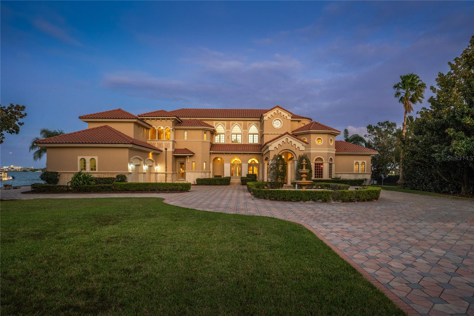 Stunning Mediterranean masterpiece perched upon the best lot in the 24-hour guard gated community of Phillips Landing. This one-of-a-kind property has never been offered for sale and sits on a private peninsula with breathtaking 180-degree views of Big Sand Lake. As you pull down the 160-foot-long driveway, past the fountain, and under the porte cochere you will know you have arrived at a very special home. Stepping through the custom iron doors, your eyes are immediately greeted by soaring 25-foot ceilings, a grand curved staircase, and a wall of windows overlooking the pool and lake. From the imported marble tile, and stone columns, to the custom woodwork and grand chandeliers, no expense was spared in the construction of this exquisite residence. The gourmet kitchen features a large center island, top-of-the-line appliances, and a large breakfast nook with windows overlooking the lake. The enormous primary suite features a separate sitting area, two massive closets with custom cabinetry, a breakfast bar, and a spa bath with exquisite marble and onyx tile, a jetted tub, and an oversized walk-in shower. There are also two additional guest suites on the first floor along with a home office, and both formal and informal living rooms overlooking the water. On the second floor you will find a billiards room, home theater, and three additional bedroom suites. As you step through the French doors to the back yard will find a resort style pool with incredible water views, a boat dock with a private gazebo on the lake, and a new sea wall that extends along the entire shoreline. For the car enthusiast, there is an oversized three car garage, and plenty of additional parking along the expansive driveway and motor court. The location simply can’t be beat, located minutes from famed restaurant row and a short drive from world class shopping and all the area theme parks, there will never be a shortage of things to do. Don’t miss your opportunity to own this lovely home.