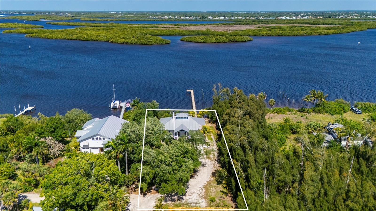 One or more photo(s) has been virtually staged. Welcome home to 27414 Misty Ave — A Phenomenal Waterfront Retreat on Peace River-- Timeless River Charm offers a bright, airy home that’s been loved, enjoyed, and meticulously maintained. A True Custom Built and Designed Home Located on the Beautiful Peace River, with 105 feet of Water Frontage, Boaters will appreciate the Private Dock(New 2025) gives way to Quick Access to Charlotte Harbor and onto the Gulf for some of the Best Boating and Fishing in all of Southwest Florida. This Home Features Three (3) Bedrooms, Two (2) Full Baths, Spacious Open Living with Soaring Ceilings, Transom Windows and a Cupola allowing ample Natural Light to flow through the spacious Living areas ideal for both hosting and everyday comfort. The kitchen features, expansive Breakfast bar along with abundant cabinetry for storage alongside modern appliances.  The Primary suite serves as a peaceful retreat with walk-in closet and an en-suite bathroom boasting dual vanities, and walk-in shower. Additional bedrooms provide flexible space for guests or a home office. Take in the Waterfront breezes on the outside deck overlooking the Peace River and a 3rd floor Roof Deck, what a place to take in the Waterfront views, the outside living space offers the perfect Waterfront setting for entertaining, relaxing, and savoring morning sunrises and evening sunsets. On the main level with ample covered space allows room to park your vehicles and all your toys, plus a spacious workshop. Whether heading out for a sunset cruise or a day on the water, this home delivers the waterfront lifestyle Punta Gorda is known for,  you will be located just minutes from Historic downtown Punta Gorda, Fishermen’s Village, Waterfront dining, shopping, golf, and community events, this exceptional property offers the perfect balance of the relaxed Florida Waterfront Lifestyle.