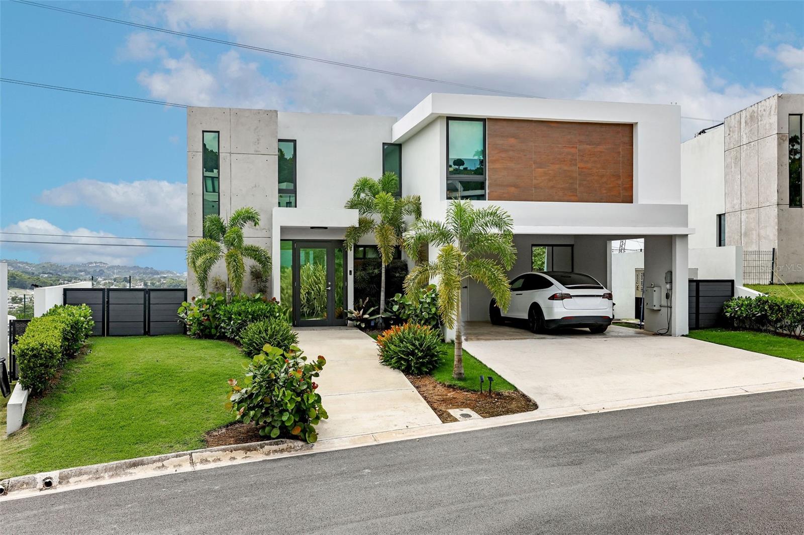 Welcome to MonteAzul, the luxury new development within the prestigious Montecielo community in Guaynabo—designed for modern living, privacy, and comfort. This exclusive gated neighborhood offers a resort-style lifestyle with 24-hour security, a stunning infinity pool, luxury fitness center, pickleball and tennis courts, landscaped recreational spaces, and a family-oriented atmosphere. As part of a new development, the property also benefits from no property taxes, creating exceptional long-term value.
This newly constructed residence features a spacious and functional layout with 4 bedrooms and an elegant open-concept design that seamlessly connects the living, dining, and kitchen areas. Expansive windows fill the home with natural light while showcasing the property’s beautiful mountain views and surrounding greenery.
Designed to maximize outdoor living, the home includes a private pool, terrace, and large yard, creating the perfect setting for entertaining family and friends or simply enjoying Guaynabo’s year-round tropical climate. The property is also fully equipped with a full generator, water cistern, and electric vehicle charging plug, offering convenience and peace of mind rarely found in newer homes.
A rare opportunity to own a modern, fully equipped residence in one of Guaynabo’s most sought-after luxury communities.