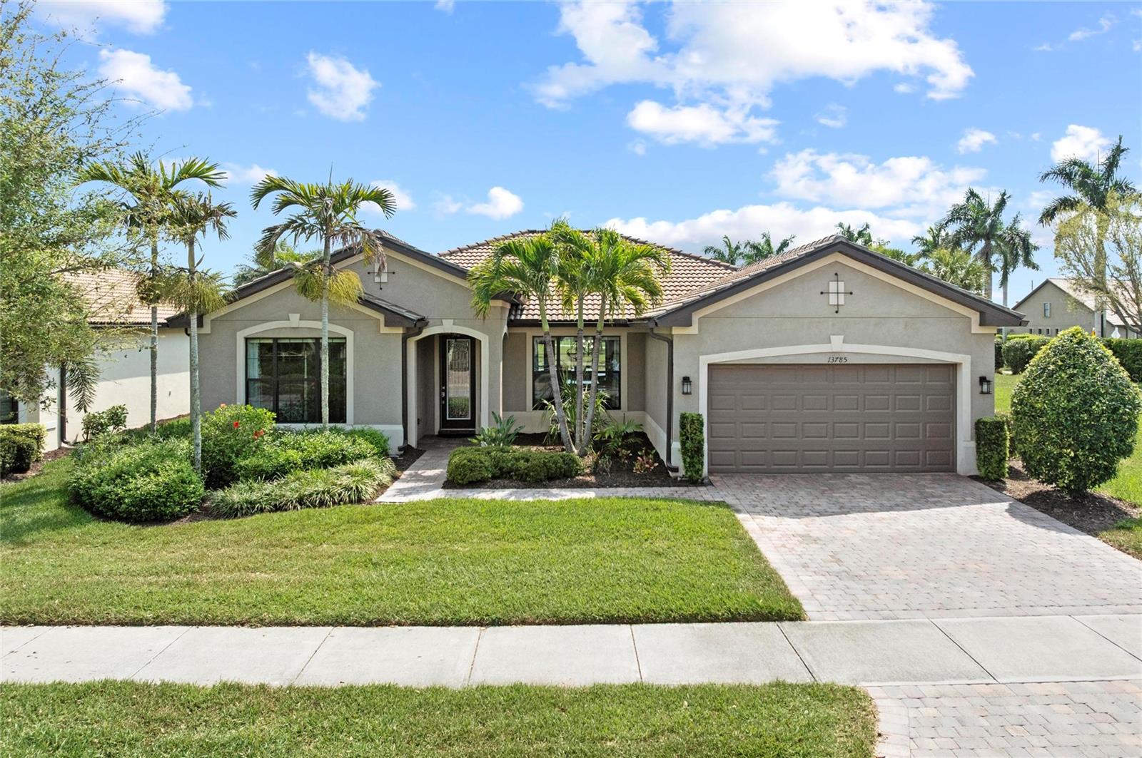 This rare Tangerly Oak model offers an exceptional opportunity to own a thoughtfully upgraded and lightly lived-in home that truly stands apart. With 2,757 square feet of living space—larger than the typical one-story Pinnacle model—this residence delivers both added space and enhanced functionality. Unlike most Pinnacle layouts, this home features four generously sized bedrooms, including a desirable second bedroom with its own private en suite bath and a large walk-in closet, perfect for guests or multi generational living.

From the moment you enter, you’ll notice upscale design elements throughout, including 8-foot interior doors, higher baseboards, and tile flooring that flows seamlessly throughout the entire home. The spacious eat-in kitchen is designed for both everyday living and entertaining, offering abundant cabinetry, ample storage, and plenty of room to gather.

A true highlight of the home is the one-of-a-kind wall of four sliding glass doors spanning over 15 feet, opening completely to the extended lanai for seamless indoor-outdoor living. The oversized corner lot provides exceptional privacy along with expansive, long water views, all with a sought-after southern exposure that fills the home with natural light—especially during the winter months.

Step outside to your own private retreat, featuring a premium Hot Spring Prism seven-person hot tub installed in 2020. Designed for a full-body hydrotherapy experience, it includes 73 jets powered by three pumps, a deeply relaxing lounger seat, a powerful footwell jet, a freshwater salt system, multi color lighting, and a backlit waterfall for added ambiance—all offering luxury without the maintenance of a full pool.

Set on an expansive 9,788 square foot executive homesite, the property also benefits from a large berm that enhances privacy and tranquility. Additional features include hurricane impact glass windows and doors throughout, including the quadruple sliders, a four-foot extended garage, and a large laundry room with plenty of space for storage and functionality.

Lovingly maintained by its original owners and used only seasonally for approximately two months per year, this home has never been rented and remains in exceptional condition. Ideally located just a short walk from the impressive 14,000 square foot Resort Center, 11,000 square foot Event Center, multiple pools, and an array of world-class amenities, this home offers the perfect blend of luxury, comfort, and convenience.