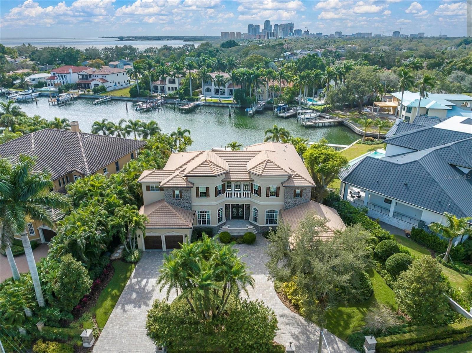 NO FLOOD CLAIMS! HIGH and DRY with NO flooding inside the house from Hurricane Helene or Milton!  Luxurious Snell Isle waterfront home boasts five bedrooms, 5 1/2 baths, and a coveted four-car garage. Gourmet kitchen seamlessly connects to the great room, offering picturesque water views from every window. Designed with ample space for family gatherings, it accommodates multiple cooks effortlessly. The walk in pantry adds a touch of practical luxury to this culinary haven. You will love the flow between Family room, Kitchen & Breakfast area! Guest en suite, first floor, insures pool access and wonderful water views. 1st-floor office is a refined workspace with built-in bookcases, strategically placed near the entrance for easy access. Its location ensures privacy from the family areas while offering a view of the surroundings, allowing you to stay connected with the happenings around you while maintaining focus. 2nd-floor primary, a spacious en suite, provides a luxurious private escape. Large walk-in closet adds to the suite's allure, combining style and functionality for an indulgent living experience. 2nd floor Den, featuring a convenient wet bar, is a cozy yet elegant area inviting a perfect retreat for relaxation and entertainment. While the 2nd floor balcony provides the perfect spot to enjoy that first cup of morning coffee, experience the magic of incredible sunrises from this elevated vantage point. Relax in this captivating outdoor oasis features a sparkling pool, an inviting outdoor kitchen with a fireplace, and a private dock for effortless access to the open waters of Tampa Bay. Nestled on a protected deep water canal inlet, offers direct access to Tampa Bay without any bridges, with potential to accommodate a 55' boat or sailboat, this is truly waterfront living at its finest. Oversized lot has 16,357 sqft, allowing for your much desired privacy! Noted, this house is pre-wired for a generator and has planned space for installing an elevator with for easy access on all 3 levels. Snell Isle offers convenient access to downtown St. Petersburg. Walkable, ride your bike or just a short drive to the vibrant cultural scene and amenities of downtown St. Petersburg. Snell Isle combines the tranquility of an island retreat with the allure of coastal living, making it an ideal haven for those seeking both relaxation and urban convenience.The perfect blend of luxury and waterfront living awaits in this stunning home.