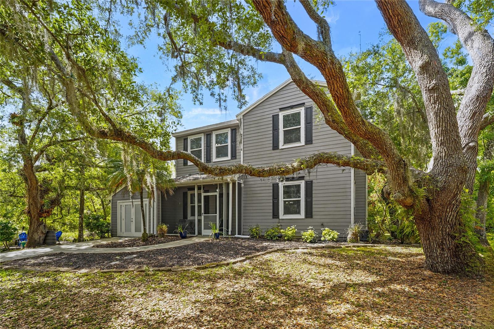 Welcome to one of Myakka's hidden treasures! This 3-bedroom, 2.5-bathroom home, perfectly positioned on 2.23 acres, is surrounded by a picturesque Florida landscape - a rare opportunity to enjoy privacy, space, and convenience all in one place. The property has been thoughtfully renovated, blending both comfort and design. As you step through the screen-enclosed entryway, you'll be delighted by durable vinyl plank flooring, crown molding, custom built-ins, upgraded lighting, and neutral tones. The kitchen is a showstopper, featuring gray shaker cabinetry, stainless steel Whirlpool appliances, sleek quartz countertops with a waterfall edge, under-cabinet lighting, and a beautiful glass tile backsplash. The family room is cozy, functional, and visually appealing, with custom built-in storage and shelving, as well as a stackstone fireplace. All of the spacious bedrooms are located on the upper level of the home. The primary suite is a relaxing retreat, featuring a luxurious en-suite with a double-sink vanity, a beautiful stone countertop, a stylish tile shower, and a generously sized walk-in closet equipped with built-in organization. Entertaining is effortless with the large deck that extends beyond the covered patio, creating a true backyard oasis filled with grand oak trees and endless potential. Multiple seating areas are in place for you to enjoy and connect with nature, along with a charming footbridge spanning the creek. In addition to the main home, there are three additional structures: two storage sheds and a versatile workshop with two climate-controlled rooms ready for customization. Upgrades include: Impact Windows (2019), Roof (2020), HVAC (2022), Septic System (2024), and Well and Pump (2025). Located just 15 minutes from all that Lakewood Ranch offers: shopping, dining, the Premier Sports Campus, Lakewood Ranch Hospital, and more. Don't miss your chance to make this one yours!