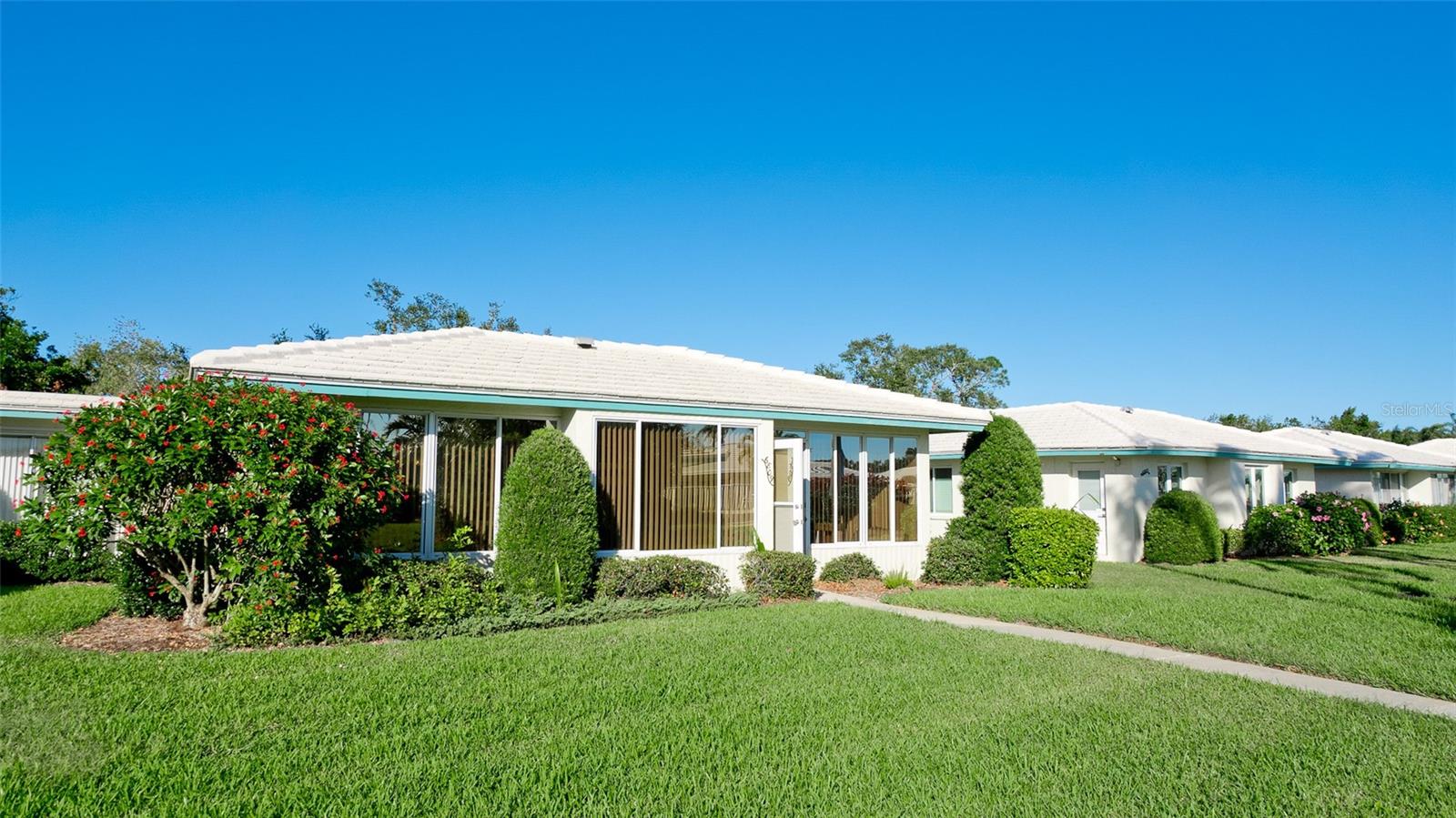 Welcome to your dream retreat in the coveted Village Green 55+ community of Bradenton, Florida! This beautifully maintained 2-bedroom, 2-bathroom residence with a versatile bonus room and 2-car garage offers 1,825 square feet of thoughtfully designed living space, perfectly balancing comfort, functionality, and style.
Step inside to discover a bright, open-concept living area that flows seamlessly into the dining room, kitchen, and bonus room—ideal for both everyday living and entertaining. The spacious kitchen provides convenient access to the laundry room and garage, making daily routines effortless. The primary suite offers a tranquil escape with a private bath and generous closet space, while the second bedroom adapts beautifully as a guest room, home office, or creative studio. A well-appointed second bathroom adds thoughtful convenience for family and visitors alike.
One of the home’s standout features is the fully enclosed porch, designed as the perfect Florida room. Bathed in natural light and offering year-round comfort, this inviting space is ideal for morning coffee, afternoon reading, or evening gatherings with friends. It extends the living area while capturing the essence of Florida’s indoor-outdoor lifestyle.
From the back entrance, you’re just moments away from the neighborhood pool, walking paths, and shuffleboard courts—all less than a minute’s stroll. Life in Village Green means enjoying expansive green spaces and a peaceful atmosphere, while still being close to Bradenton’s pristine beaches, vibrant shopping, dining, and entertainment.
This home is more than a place to live—it’s a lifestyle. Imagine morning walks under the Florida sun, afternoons by the pool, and evenings entertaining in your spacious living room or relaxing in your Florida room. Don’t miss your chance to own a piece of paradise in one of Bradenton’s most desirable neighborhoods. Schedule your private showing today!