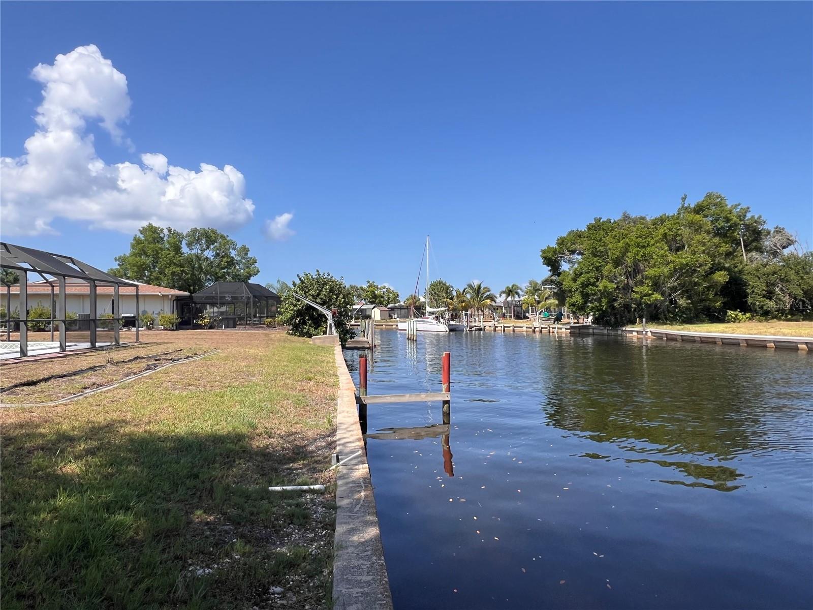 Rare opportunity to secure a prime waterfront homesite in one of Port Charlotte’s most desirable boating locations. This oversized 100 x 125 ft sailboat-access lot is ideally positioned just five lots from open water, offering quick, direct access to Charlotte Harbor with no fixed bridges.
Enjoy stunning western rear exposure, perfect for capturing breathtaking sunsets over the canal—an ideal setting for a luxury custom home with outdoor living, pool, and entertaining space.
Located directly across from the Charlotte Harbor Yacht Club, which has recently been approved for a transformative redevelopment featuring high-end market-rate condominiums, retail, and major clubhouse improvements, this property is poised to benefit from significant area growth and rising values.
Unbeatable location just off Tamiami Trail and Edgewater Drive, minutes to Sunseeker Resort, downtown Punta Gorda, and an abundance of waterfront dining, shopping, and everyday conveniences.
The property currently includes an existing home and pool that could be renovated; however, the seller is willing to remove the structure, creating a prime opportunity for new construction.
Public utilities are already in place, including water and sewer, and impact fees are expected to be minimal or not required as they were paid with the original construction.
Situated in a non-HOA neighborhood with no association fees or deed restrictions, this property offers flexibility for building and investment.
Whether you’re building a personal waterfront retreat or investing in a premium location, this lot offers size, exposure, boating access, and future upside that is increasingly hard to find.