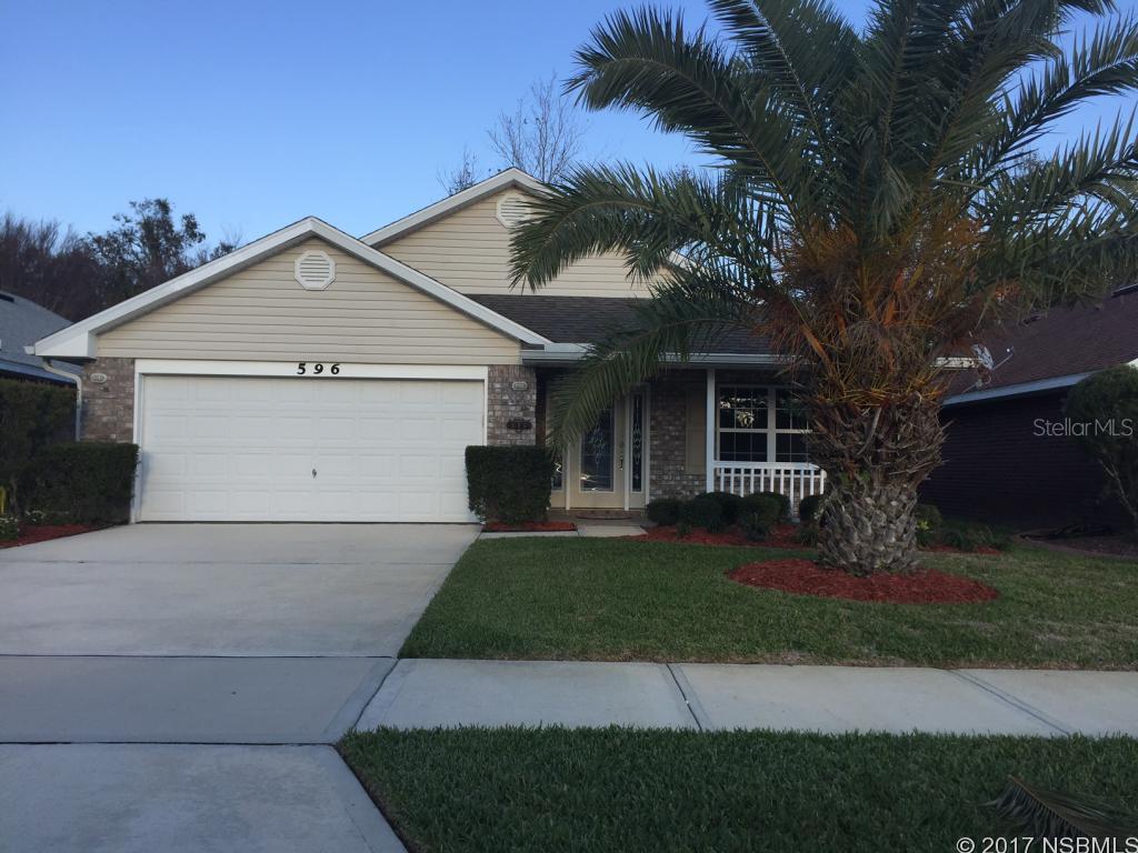 Located in the Gated Coral Trace community which has a clubhouse, community pool and work out room, you will find this beautiful brick 3 bedroom 2 bath 2 car garage home - Modern home with new tile throughout, stainless steel appliances, electric fireplace with remote and an interior laundry area.  The screened patio backs up to conservation area. Rent includes lawn service and HOA fees