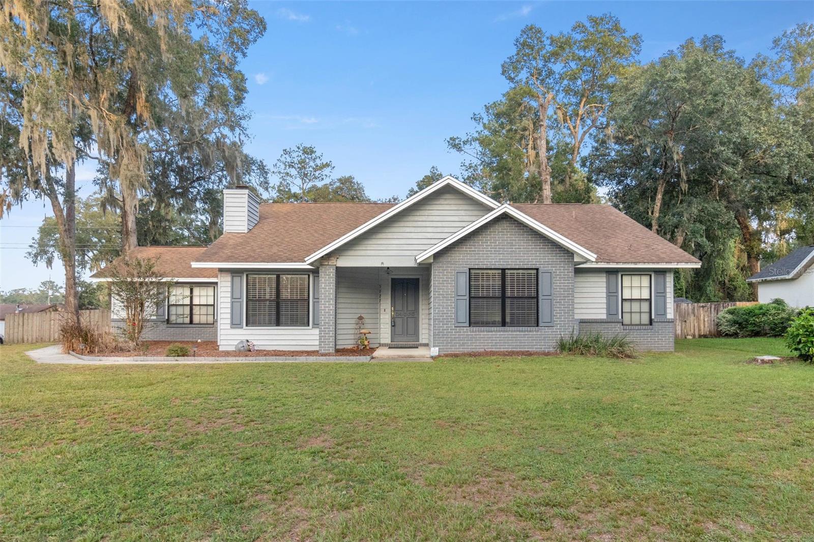 HOME WARRANTY INCLUDED FOR BUYERS!
Explore the charm of this 3/2/2 corner lot haven in Southeast Ocala, boasting a tranquil, family-friendly locale without HOA constraints. Recently updated with stylish vinyl plank flooring and outdoor painting, the home features a spacious lanai adorned with Lima Gris tile flooring. Noteworthy improvements include a 2018 hot water heater replacement and a May 2023 update to the AC condenser fan motor and run capacitor.

Step into the large living room, graced with a cathedral ceiling, a ceiling fan, and a stone-faced, wood-burning fireplace for cozy gatherings. The kitchen, equipped with stainless steel appliances, hosts a sizable stainless steel sink featuring an InSinkErater instant hot water dispenser and a convenient sink-top garbage disposal button. Ample storage is ensured with a pantry and counter space, including an under-counter two-tiered lazy Susan.

Enjoy breakfast in the charming nook with bay windows overlooking a fenced, private yard. Entertain on the lanai, perfect for barbecues and relaxation. The formal dining room offers flexibility as a movie room, family space, or office. The master bedroom provides comfort with dual closets, one being a walk-in. The expansive bathroom boasts two vanities, a sunken jacuzzi tub, and a separate shower. Additional features include a laundry room, a second full bath, and two spacious bedrooms with ceiling fans.

Nestled on .55 acres in the well-maintained Regal Woods subdivision, this home, situated outside city limits, utilizes Duke energy and Marion County utilities for water.  The back yard goes beyond the wood fence to the tree line. This residence promises comfort and possibility no matter what your situation. Visit and envision the potential of your future dream home.