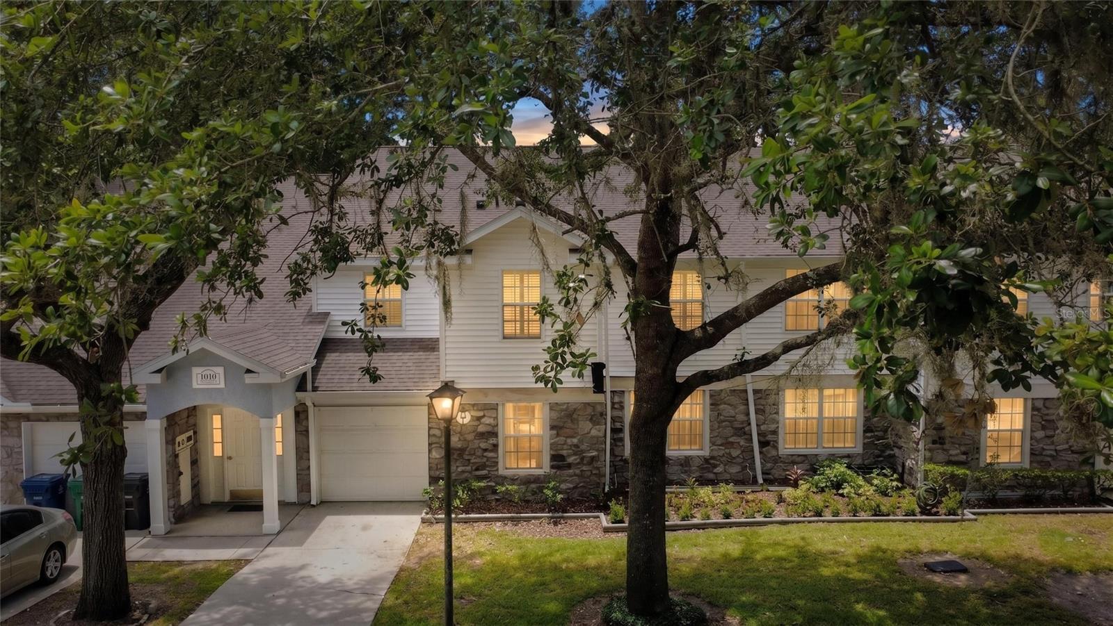 Virtually Staged. Welcome to this stylish and spacious townhouse-style condo nestled under a canopy of mature oak trees in the sought-after Loch Vail community of Apopka. With stone accent exterior and lush surroundings, the curb appeal sets the tone for everything inside — and this one is absolutely turnkey and move-in ready.
The open living, dining, and kitchen areas feature high vaulted ceilings, plantation shutters, and a functional layout perfect for entertaining. The kitchen is a home chef's dream with Carrara quartz countertops, white shaker cabinets, a mosaic tile backsplash, GE Profile stainless steel appliances including a double convection oven, and an elegant chandelier. Just steps away, a bonus butler's pantry with built-in shelving adds valuable storage, and the dining room features built-in cabinetry with a roomy pantry.
Bedrooms are split from the living areas for complete privacy, each generously sized with ceiling fans and plantation shutters. Both bathrooms have been tastefully updated — the ensuite bath showcasing ceramic plank flooring, a quartz vanity with backlit LED mirror, and a gorgeous walk-in shower. A laundry closet with stackable washer and dryer is included.
Major upgrades include a new A/C (2019), fully remodeled kitchen (2021), new electric water heater and ensuite bath remodel (2023), and freshly cleaned air ducts (2025). The garage offers attic space and overhead storage hangers for extra convenience.
Step out onto the screened balcony with roll-down privacy screens and enjoy a peaceful view of the resort-style community pool and cabana below. HOA covers water, cable, internet, building insurance, and exterior maintenance — truly lock-and-leave living. Conveniently located near major roadways, medical facilities, shopping, dining, and two international airports.