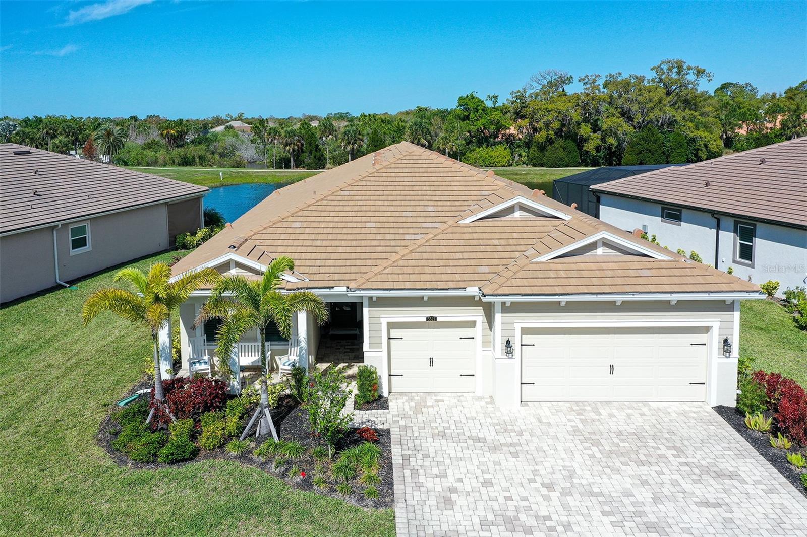 An Elegant Gem best describes this meticulously maintained home in the popular, newer gated community of Sunrise Preserve, with no CDD and low HOA fees. Perfectly situated on a wide lakefront lot near the front of the community close to the Resort Style Clubhouse.  All IMPACT WINDOWS and DOORS. This highly sought-after Jubilee Model has 4 large Bedrooms, 3 full baths, and 8 ft doors.  The Inviting Front Porch leads you into a stunning residence featuring custom millwork, tray ceilings, crown moldings and Level 5 neutral tile floors. High-end window treatments including white plantation shutters and 8 ceiling fans.  A chef-inspired gourmet kitchen boasts white cabinetry with glass doors and soft close drawers, an oversized quartz island, and undermount lighting in addition to upper cabinet lighting. Upgraded stainless steel appliances including a Bosch Refrigerator, gas cooktop and a generous pantry.  A spacious owner’s retreat exudes comfort and sophistication.  The en-suite bath features dual vanities, quartz counters, a large walk-in shower with frameless glass, and an expansive walk-in closet.  3 additional bedrooms and 2 baths are located on the opposite side of the house. Step outside to the enclosed, pavered lakefront lanai with panoramic seamless screening to enjoy sweeping water and nature views year-round, along with a fully equipped, brand new outdoor kitchen with gas grill, sink and refrigerator. Hurricane-Rated Roll Down Power shades protects the lanai. The 3-car garage has epoxy flooring, a sink, and a tankless hot water heater. Residents enjoy a resort style lifestyle with a stunning clubhouse and bar lounge, state of the art fitness center, yoga studio, heated pool & spa, pickleball, tennis, bocce ball courts, as well as inviting social spaces. Professional landscaping is included in the low HOA fee. Most furnishings are available for purchase via a separate contract.