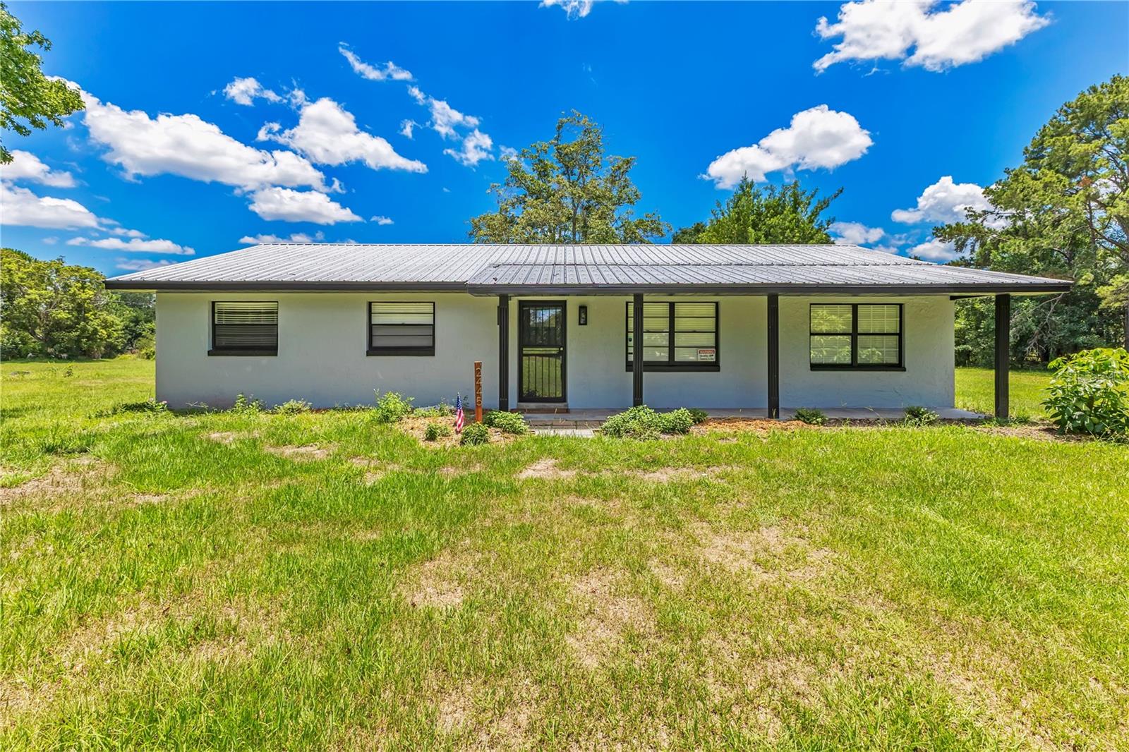 Situated on 4.42 acres, this beautifully maintained 3-bedroom, 2-bathroom home offers the perfect combination of privacy, functionality, and country charm. Positioned on a desirable corner lot, the property provides plenty of space to spread out while offering endless possibilities for outdoor living, recreation, or future expansion. Inside, you'll find a spacious and inviting layout featuring two separate living areas, providing flexibility for everyday living and entertaining. The open kitchen offers abundant cabinetry, generous counter space, stainless steel appliances, and custom built-in shelving, creating both style and functionality. Just off the main living area, elegant French doors lead to a versatile second living room or formal dining room, allowing the space to adapt to your lifestyle. Large windows throughout the home fill the interior with natural light, creating a bright and welcoming atmosphere. The spacious primary suite provides a relaxing retreat, while two additional bedrooms offer comfortable accommodations for family or guests. Both bathrooms are thoughtfully positioned for everyday convenience. Step outside and discover an abundance of organic fruit trees along with organically enriched soil, creating an ideal environment for gardening, homesteading, or enjoying your own fresh harvest. With plenty of additional room for recreational activities, animals, equipment, or future improvements, the possibilities are endless. A detached garage/workshop provides valuable space for storage, hobbies, or projects, while the mature trees and expansive grounds create a peaceful setting with added privacy. If you've been searching for acreage with a move-in-ready home, versatile living spaces, and endless potential, this property is an exceptional opportunity. Enjoy the privacy of country living while remaining just minutes from shopping, dining, schools, the Saint Cloud Lakefront, and major roadways for an easy commute.