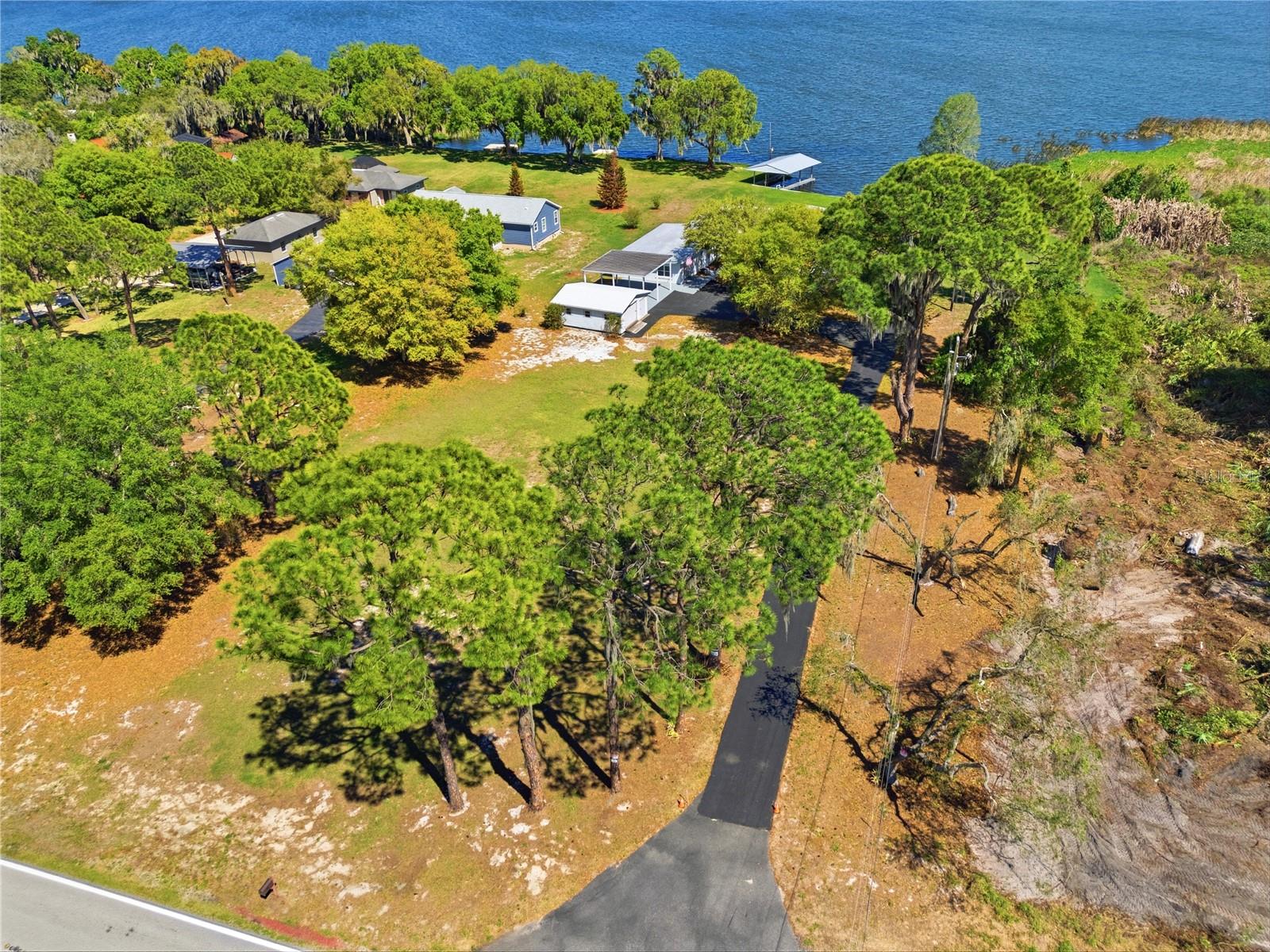 Dream of chasing trophy largemouth bass or filling the cooler with tasty speckled perch? Welcome to 8342 W Lake Marion where you'll experience the beauty of Florida lakefront living on the shores of Lake Marion, a pristine 3,000+ acre lake known for its natural shoreline, exceptional fishing, and abundant wildlife. Situated on just over 1 acre with no HOA, this updated and well kept home offers privacy, space, and a lifestyle centered around the water and nature. The home features over 2,000 sqft of living area and more than 3,200 sqft under roof, including garage, workshop, and covered parking—ideal for storing boats, equipment, and recreational vehicles. Inside, the home opens to wide, open living spaces filled with natural light and expansive lake views. The main living area showcases tile flooring and seamless flow into the kitchen and dining spaces, all designed to take full advantage of the waterfront setting. Large windows and glass doors frame the lake from nearly every angle, creating a constant connection to the outdoors. The beautiful kitchen is both functional and inviting, featuring granite countertops, custom wood cabinetry, stainless steel appliances, and a convenient pass-through to the dining area, making it ideal for both everyday living and entertaining. The primary suite is generously sized, with ample closet space and an en-suite bath with custom cabinetry, granite countertops and a walk-in shower. The guest bedroom and guest bathroom are both equally spacious and well-appointed. One of the standout features of the home is the expansive screened porch, providing a comfortable outdoor living space where you can relax, entertain, and take in sweeping views of the lake year-round. Step outside and fully embrace the waterfront lifestyle with a private dock and covered boathouse, making daily boating and fishing effortless. Lake Marion is widely known for trophy largemouth bass, speckled perch, bluegill, and catfish, while its natural shoreline attracts abundant birdlife, creating a peaceful and ever-changing backdrop. Additional features include a detached garage with workshop, multiple storage areas, and a large covered carport, offering flexibility for hobbies, storage, or outdoor equipment. What truly sets this property apart is its proximity to thousands of acres of protected land. Just minutes away, the Lake Marion Creek Wildlife Management Area spans over 8,000 acres of preserved Florida wilderness, offering trails for hiking, wildlife viewing, and exploration through pine flatwoods and oak hammocks. Nearby, the Bellini Preserve adds even more protected shoreline and native habitat, while Allen David Broussard Catfish Creek Preserve State Park and The Nature Conservancy's Disney Wilderness Preserve provide additional opportunities for hiking, birdwatching, and experiencing Florida’s natural ecosystems all under a 1 hour drive. Together, these conservation areas create a setting where nature isn’t just nearby—it’s part of your everyday life. Located near Haines City and Davenport yet tucked away in a peaceful, natural setting, this property offers the perfect balance of privacy and accessibility. Whether you're seeking a full-time residence, weekend retreat, or a place to truly connect with nature, this Lake Marion property represents a rare opportunity to own a piece of authentic Florida lakefront living.