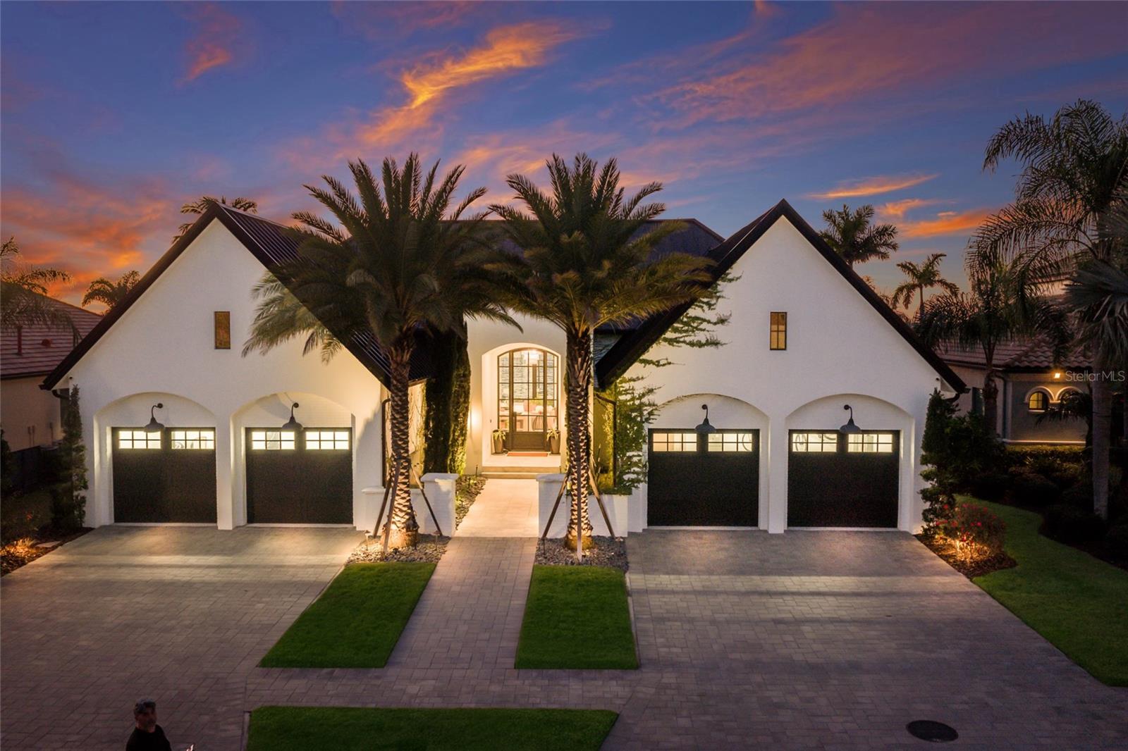 WELCOME to a breathtaking WATERFRONT masterpiece in the EXCLUSIVE double-gated BOATING community of The Reserve at Harbour Walk, where a PRIVATE deep-water DOCK on the Manatee River with direct access to the Gulf of Mexico sets the stage for a life of unmatched luxury, tranquility, and adventure. Built by CAMLIN Custom Homes, this 5,147 sq ft CUSTOM ESTATE offers 4 bedrooms plus a den or office, 3.5 baths, and a 4 car garage, all designed with a peaceful, Zen inspired aesthetic where every detail has been thoughtfully curated and flawlessly executed. A dramatic GLASS and STEEL front door opens to soaring, light-filled interiors with blue-water views that draw your eye straight through the home to the pool and river beyond. The living room is a showpiece with a custom CONCRETE GAS FIREPLACE, illuminated built-in shelving, wood beams in the vaulted ceiling, and an entire wall of oversized windows capturing the serene backdrop. The chef’s kitchen showcases custom cabinetry, MARBLE countertops and backsplash, a massive entertainer’s island with a thick granite slab, Belfast sink, seating, gold accents, and world-class appliances including a SUB-ZERO designer series refrigerator and freezer and a rare LACANCHE UL SULLY CLASSIQUE range IMPORTED from France, plus a custom pantry behind an iron and steel sliding door. The open dining area flows seamlessly for entertaining, while an additional family room with double FRENCH DOORS offers a relaxed escape to the lanai. The owner’s suite is PRIVATELY tucked away and features CUSTOM his-and-hers closets, a spa-inspired ENSUITE bath with a glass enclosed STEAM shower with twin showerheads, built-in bench, side jets, a garden tub, dual vanities, a dedicated makeup area and private lanai access beneath a tray ceiling with custom WOOD BEAMS. Two additional bedrooms share a beautifully appointed Jack-and-Jill bath with marble countertops, dual sinks, and a tub/shower combo. A STUNNING temperature-controlled wine room enclosed in iron and glass with custom cabinetry adds a dramatic focal point for entertaining. Upstairs, you will find a fourth bedroom with custom BUILT-INS, a MEDIA and GAME room with wood beams, river views, and a bespoke WET BAR with sink and refrigerator drawers, along with a flexible FITNESS AREA, a sunlit OFFICE with water views, and a full bath with an oversized glass walk-in shower and custom marble-topped vanity. The entire home is equipped with HURRICANE IMPACT GLASS for peace of mind. Step outside to your private RESORT with a pool and spa overlooking the water, a custom WOOD-BURNING fireplace with seating, a charming DOUBLE SWING, checkered-pattern lanai tile, a fully equipped OUTDOOR KITCHEN and outdoor SHOWER, creating the ultimate space for relaxation, entertaining, and unforgettable SUNSET evenings. Your PRIVATE DOCK is fully equipped with a 16,000 lb BOAT LIFT, TWIN JET SKI LIFT, and fiberglass HEAT-RESISTANT composite decking, creating the perfect launch point for boating, fishing, paddle boarding, and sunset cruises. Residents of this private enclave enjoy pickleball and tennis courts, a playground, kayak and canoe launches, and peaceful walking paths, all within a custom home community known for its LUXURY, privacy, and natural beauty. As a bonus, the JET SKIS ARE INCLUDED with a full-price offer!!! This residence is move-in ready and offers a rare opportunity to own a waterfront sanctuary where elegance, craftsmanship, and lifestyle come together in perfect harmony.