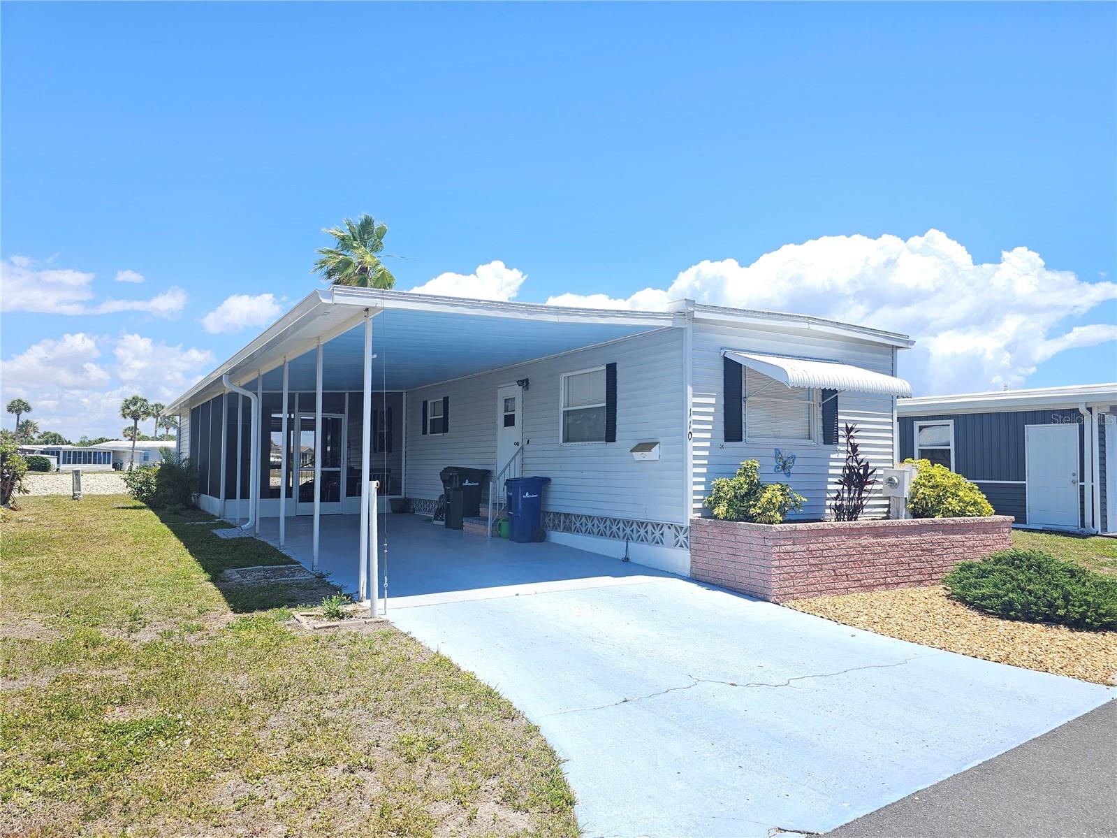 One or more photo(s) has been virtually staged. If you have been searching for an affordable Florida home with peaceful WATER VIEWS, LOW MONTLY FEES, and an active community lifestyle, this is a must-see opportunity. Located in Venice Isles, one of the most desirable 55+ mobile home communities in Venice, Florida, this charming 2-bedroom, 1.5-bath single wide with a large Florida room offers comfort, updates, and an unbeatable location. Set on a LAKEFRONT LOT with recently UPDATED RIP RAP SHORELINE PROTECTION, this property enjoys beautiful water views and is just steps from Clubhouse #1 and one of the community swimming pools. Whether you are looking for a seasonal retreat or full-time Florida living, this location checks all the boxes. Important improvements have already been completed, including a NEW ROOF-OVER INSTALLED JUNE 2023 with TPO membrane roofing that extends over the home, carport, lanai, and shed—providing added durability and peace of mind. Inside, the home features a functional bright living spaces and a spacious Florida room, perfect for relaxing, entertaining, hobbies, or enjoying the lake views year-round. The open living and dining areas create a welcoming flow, while the two-bedroom layout offers flexibility for guests, office space, or seasonal visitors. Outside, you will appreciate COVERED PARKING, additional storage, and easy access to all the amenities that make Venice Isles so popular. Venice Isles is a resident-owned 55+ co-op community known for its LOW MONTHLY FEES, friendly atmosphere, and AND ACTIVE SOCIAL ACTIVITIES. Residents enjoy TWO COMMUNITY POOLS, a LARGE TIKI HUT at the main pool, TENNIS COURTS, PUTT PUTT GOLF, SHUFFLEBOARD, HORSESHOES, CLUBHOUSE EVENTS, and a full calendar of activities. Located just minutes from Venice Beach, the Island of Venice, shopping, dining, golf, fishing, and top-rated medical facilities. You are also within easy reach of Siesta Key Beach and Sarasota’s arts, culture, and entertainment. If you are looking for a Venice, Florida home with lake views, major roof updates, low fees, and resort-style amenities, this property is an excellent opportunity to make your move to paradise.