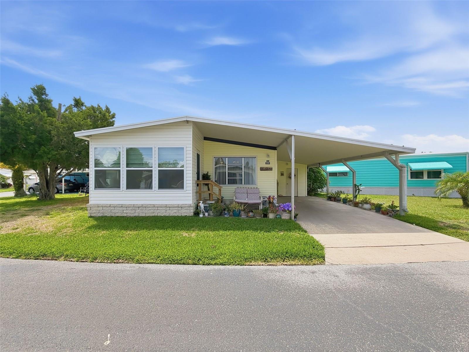 Welcome to easy Florida living in this active 55+ cooperative waterfront community! This well-maintained 3-bedroom, 1-bath home features a covered carport and a bright, inviting floor plan designed for comfortable everyday living. The galley-style kitchen offers a convenient closet pantry and is situated adjacent to the dining area, which showcases a charming built-in china cabinet for added storage and character. A dedicated laundry closet with built-in cabinetry helps keep household essentials organized. Relax and enjoy your morning coffee or evening breeze from the wonderful glass-enclosed front porch, providing additional living space year-round. Ceiling fans throughout most of the home help keep the interior comfortable and energy efficient. Residents enjoy an impressive array of amenities, including two community pools, shuffleboard courts, tennis courts, pickleball, bocce ball, and a vibrant social atmosphere. The low monthly HOA fee of just $310 includes lawn maintenance, water, sewer, trash service, basic cable, and access to all community amenities. For boating and outdoor enthusiasts, the community offers a private boat ramp and marina with docking slips available by assignment. Residents may also utilize one storage space in the community storage compound for recreational vehicles, trailers, boats, boat trailers, or canoes/kayaks, subject to availability. Don't miss this opportunity to enjoy an affordable, maintenance-free lifestyle in one of the area's most desirable active adult communities!