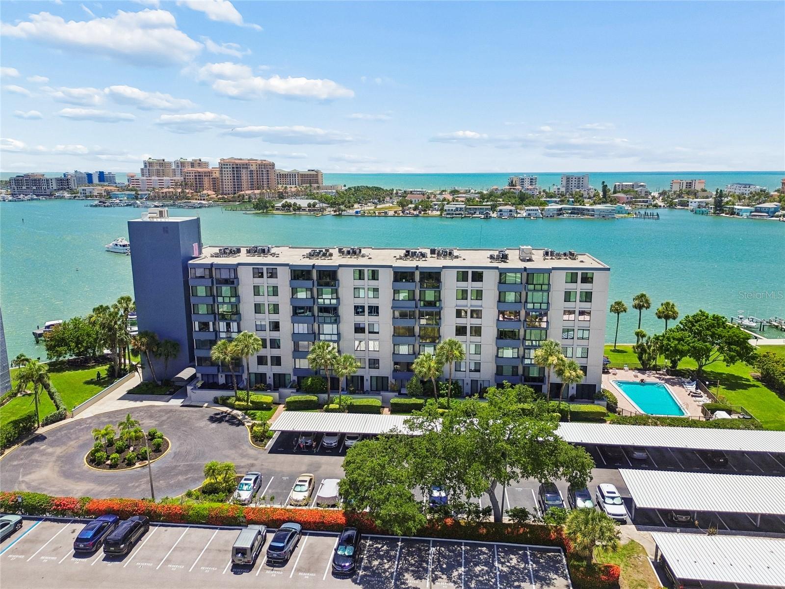 Experience the best of Island Estates living in this pristine, UPDATED, FULLY FURNISHED, move-in ready 2-bedroom, 2-bath condominium. Showcasing chic décor, premium finishes, and an open floor plan, this beautifully updated residence features luxury vinyl flooring throughout. The gourmet kitchen offers stainless steel appliances, solid surface countertops, a breakfast bar, and a stylish dry bar in the dining area that's perfect for entertaining. Located on the fourth floor, this bright and inviting home enjoys beautiful morning sun and partial Intracoastal water views. The spacious floor plan offers generously sized bedrooms, with the guest bedroom large enough to accommodate two queen-size beds. The primary suite features two closets, including a walk-in closet, along with abundant storage throughout the home, including storage solutions throughout the property. In unit washer and dryer are also included for added convenience. Major updates include the HVAC system and water heater (2020). This secure building offers key fob entry, security cameras, an assigned covered parking space #20.  The HOA fee includes cable, water, and high-speed internet. Perfectly located on Island Estates, you'll be just minutes from Clearwater Beach and within walking distance of Publix, banks, restaurants including Island Way Grill, shops, the Clearwater Marine Aquarium, and a variety of waterfront activities. Enjoy scenic waterfront walks, bike rides, or simply relax and embrace the coastal lifestyle this highly desirable community has to offer. Boating enthusiasts will appreciate the private community dock on the Channel, with boat slips available for rent through management (subject to availability), as well as a kayak rack. Spend your evenings relaxing by the waterfront pool or private dock while watching spectacular sunsets, dolphins, and boats cruise by. Don't miss this exceptional opportunity to own a beautifully updated, fully furnished waterfront condominium in one of Clearwater's most desirable communities. Furnishings are included, making this the perfect primary residence, vacation home, or investment opportunity.