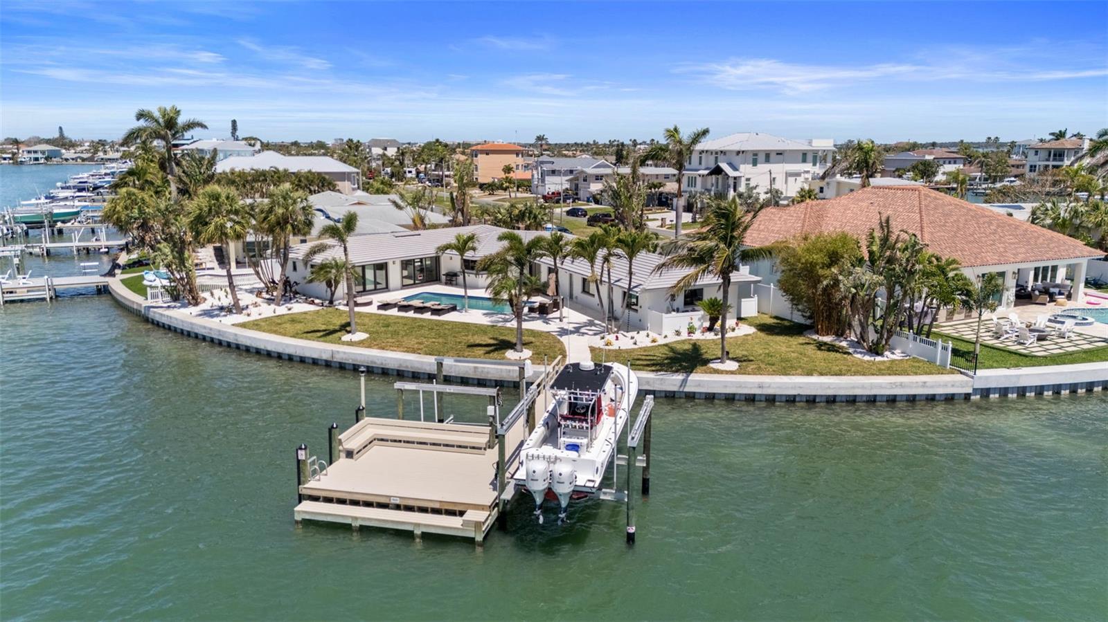 Sky's The Limit Development Group proudly presents this stunning, rare waterfront gem offered to enjoy in it’s current coastal charm, or as the perfect canvas for your dream home. Whether you envision a custom-built mansion on this breathtaking site or prefer to build on your own lot or an alternate location, our team is ready to bring your vision to life with unmatched craftsmanship and design expertise. Imagine awakening each morning to the gentle whisper of sea breezes and the soft cadence of waves brushing against the seawall, your day beginning with panoramic, unobstructed views of Boca Ciega Bay. This extraordinary waterfront property boasts an impressive 166 feet of water frontage with direct access to the Gulf—perfect for seasoned boaters and sunset cruisers alike. Dolphins play just feet from your private dock as you sip your morning coffee or unwind in the evening, soaking in breathtaking sunsets from the comfort of your backyard oasis. Tucked away at the end of a quiet cul-de-sac in the prestigious Isle of Palms on Treasure Island, this beautifully restored 4-bedroom, 3-bath, 2,500-square-foot home offers a seamless blend of coastal charm and modern comfort. Nearly every room in the home opens to the water, inviting you to experience the tranquility of outdoor living year-round. A sparkling pool, tropical landscaping, and a brand-new composite dock with two boat lifts and a newly installed seawall complete this waterfront dream. Just around the corner, you’ll find the iconic John’s Pass Village—offering deep sea fishing charters, dolphin excursions, boutique shopping, and some of the best coastal dining on Florida’s Gulf Coast. Whether you’re boating out to the Gulf or strolling the local boardwalk, everything you love about Florida living is at your fingertips. And for those with grander visions, this rare parcel offers the opportunity to create something truly spectacular. Sky’s The Limit Development Group is ready to bring your dream to life—offering the potential to completely redevelop the property into a breathtaking custom-built three-story mansion with views stretching as far as the eye can see. Inquire today about building your dream home on this slice of paradise—where every sunset is a masterpiece and every day feels like a vacation.