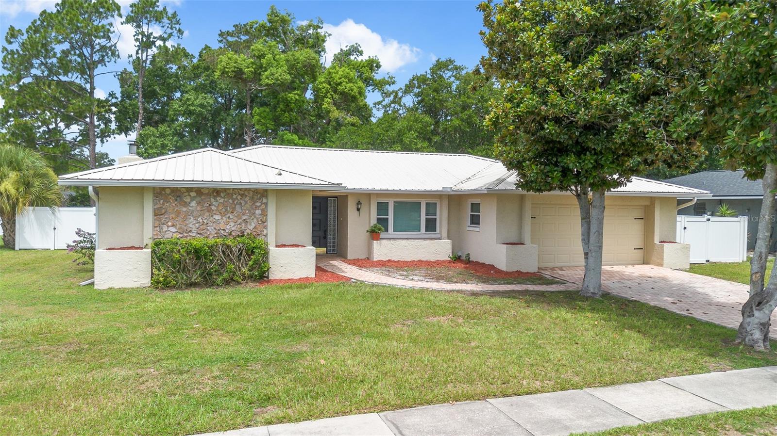 Welcome home to your turn key and completely remodeled single story residence in the heart of Dr. Phillips.  The brick paver driveway and walk way lead you to the inviting foyer and open floor plan with upgraded ceramic tile floor throughout.  This charming home features upgraded brand new double pane windows throughout, a newer metal roof for maximum efficiency and a re-pipe in 2020.  The open floor plan features an inviting family room with a cosy masonary brick fireplace.  The gourmet kitchen is a chef's dream true with upgraded cabinets, stainless steel appliances, granute counter tops and a kitchen sink offering serene views of your private backyard.  The oversized kitchen island and breakfast bar are sure to satisfy the most talented chefs offering plenty of space to prepare and serve guests your most tantalizing culinary creations.  The dining room is conveniently located adjacent to the kitchen making this floor plan ideal for entertaining.  The master retreat features an en-suite bath and the 3 addtional spacious bedrooms in a split floor plan configuration share the 2nd bath with a dual sink granite vanity and separate tub and shower features a mosaic tile motif.  The washer and dryer have been conveniently located to the inside for your convenience.   Bedroom 4 features serene views of the over sized 29' x 13' covered patio; your ideal privately fenced sanctuary to escape to after a long day to enjoy your favorite libation.  The sparkling pool and fenced backyard are ideal for your growing family and pets.  All this in a great location in the heart of Dr. Phillips with A-rated schools, close to the all the area attractions, major highways and around the corner from the YMCA and minutes to the world famous restaurant row to curb any craving that you may have.