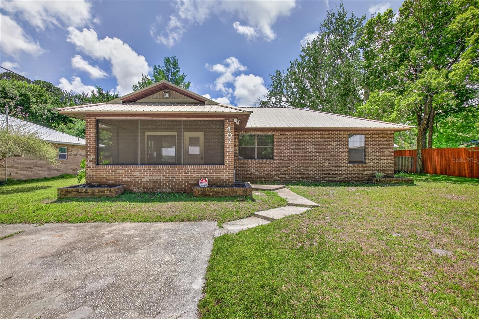 Welcome home to this charming 3-bedroom, 2-bath residence conveniently located just minutes from downtown! This beautifully maintained home features a newer metal roof, a 2024 HVAC system, and a 2024 water heater, offering peace of mind for years to come. Inside, you’ll find updated stainless steel appliances that complement the functional and inviting kitchen space. Step outside and enjoy the ultimate backyard retreat with a spacious covered porch complete with a cozy wood-burning fireplace and a built-in pizza oven — perfect for entertaining family and friends year-round. The large, fully fenced backyard provides plenty of room for pets, play, or gardening. In the front, a generously sized covered patio creates the perfect spot to relax and unwind. This home combines comfort, updates, and outdoor living all in one fantastic location!