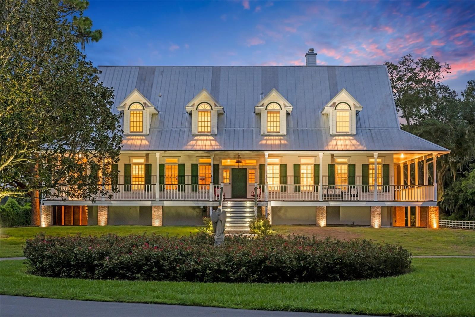 South Carolina "Low Country" style manor home situated on 10.52 luxurious lake front acres just 10 minutes from the heart of downtown Winter Park! From the moment you enter the private gated entrance, and cruise down the newly paved drive, you will be in awe of this impressive estate! Passing by the newly fenced green pastures, and the state of the art 10-stall center aisle barn, you will notice a quaint guest cottage, and its perfect location on these premises, tucked toward the edge of the sprawling acreage and out of the line of sight of the breathtaking beauty that is the main house. Beyond the main home you will find the serenity of a forgotten “old Florida” with stately cypress trees surrounding a lagoon with fountain and beyond, the awe-inspiring panoramic view of 400-acre Lake Howell! The Main home boasts a fabulous 3-story design featuring wrap-around balcony style porches, a third-floor balcony and a newly added ground level back porch with retractable screens overlooking a gorgeous salt-water pool and spa. All 3 levels of this home have primary suites. The finely crafted interior finishes include 10 foot ceilings, solid wood flooring, impressive millwork and quintessential designer touches throughout. The ground floor level includes a large kitchen, a well appointed bedroom suite and spacious living and dining areas. Enter the main floor from the enchanting front steps of the home.The second level boasts spectacular views through french doors spanning the entire back of the home and offers spacious entertaining spaces to include charming living room with wood burning fireplace, a spacious dining room, a gorgeous farm-style eat-in kitchen, a well appointed butler's pantry, laundry room and impressive primary suite with it's private den and soothing bathroom. The uppermost level boasts 5 bedrooms and 3 full baths with a primary suite opening onto a balcony giving unparalleled views of the grounds and the private Lake Howell. The immaculate grounds have been manicured to perfection with a multitude of recent additions including the newly built pool/spa, a storybook bridge over the lagoon, a custom boat dock with lift, new irrigation and sod, grounds illumination, a charming roped/illuminated boardwalk, a new secure front gate system, a full house generator, complete fence replacement, brick pavers, complete asphalt surface renewal and more!  The idyllic and well appointed barn has a tack room with shower, laundry facility, a newly installed roof, a wash station, fly spray station and all 10 stalls are fully irrigated and wired for electricity. In addition the front pastures have two covered polestalls adding additional livestock or equipment storage. This is truly a remarkable "one of a kind" offering in the enchanting town of Winter Park, Florida. Schedule your private tour today?