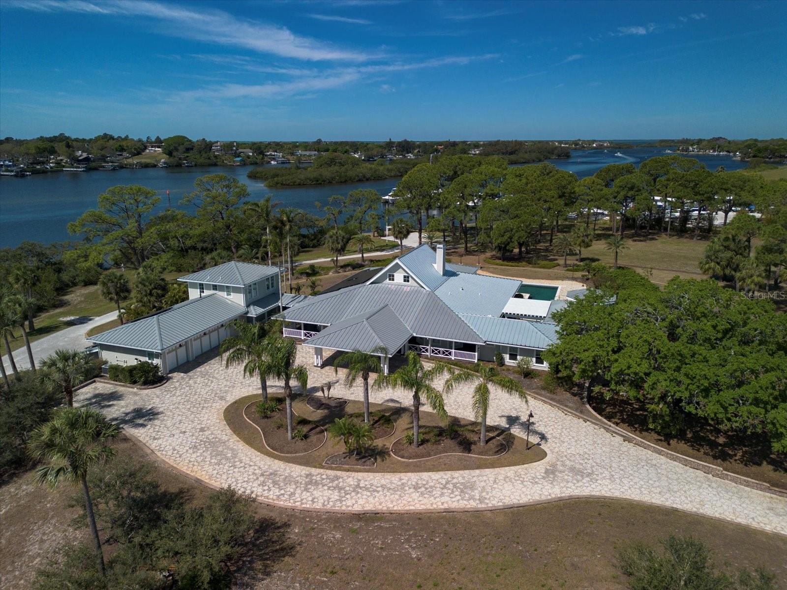Listing includes vacant lots at 02 27 15 75816 000 0170, 02 27 15 00000 430 0210 and 02 27 15 27486 000 0110 totaling over 13 acres. 
Impressive address- a once in a lifetime opportunity to own THE ANCLOTE ESTATE. Situated within SEVEN ACRES of the Anclote river waterfront, this idyllic property is incomparable and a very rare opportunity to own one of the last parcels of the Nature Coast. Accessed through an impressive private entry to the welcoming porte-cochere, this gated compound consists of the main residence, guest house which is connected by a covered breezeway, and cabana with additional guest suite offering in total, seven bedrooms. Nestled in a protected elbow of the Anclote river, the property offers over 350 feet of an outstanding waterline with open and expansive views. Cruise to the Gulf of Mexico in less than 5 minutes for the ultimate in fishing, or relaxing for all day enjoyment, this oasis offers the new owner abundant privacy in a world of comfort! Within the main home one feels the expansive space with 18’ ceilings, endless natural light and beautiful water and Marina views through the walls of accordion glass doors. Perfect for entertainment or relaxation, open space and expansiveness invite the tropical outdoor setting into these notable open areas. The three-way split bedroom ensuite plan offers extensive privacy. The spacious and open kitchen enjoys open water views from all areas. A culinary masterpiece that all Chefs will appreciate, abundant storage, commercial refrigeration, gas range, handsome cabinetry and extensive counter areas with additional seating and an enormous pantry enhance this area so rich in details. The kitchen flows seamlessly into the great room area and the wrap around porch. Measuring 35’ x 35’ the exterior verandah wraps around the pool and continues to connect the large cabana with en suite. This large space is suited for a multitude of options including additional guest quarters, game/billiard room, bonus area for family gatherings or exercise room.  A generous sized one-bedroom guest quarters, ensuite, also shares the open verandah. On the opposite side of the residence, a large guest suite offers 2 bedrooms on the main level and an inviting open great room with full kitchen on the second level. Three car garage, secondary storage garage suited for a golf cart, additional storage for pool or boat equipment are additional features of this amazing estate. The entire setting is reminiscent of an era where large parcels such as this were the norm and not an exception. So many endless possibilities! Inquire today!