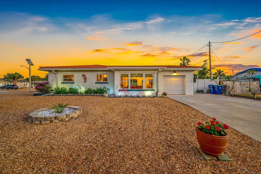 Pride of ownership shines throughout this beautifully maintained solid block home in the highly desirable neighborhood of South Pasadena. Situated on a corner lot, this single-level residence offers 2 bedrooms, 2 bathrooms, a 1-car garage, and a spacious covered lanai designed for enjoying the Florida lifestyle year-round. Step inside and be welcomed by a bright, open living room featuring gleaming polished terrazzo floors and an abundance of natural light.  The recently remodeled kitchen is a true showpiece, boasting Ultra White quartz countertops, striking Emerald Green Spanish tile backsplash, abundant white cabinetry, a closet pantry, and brand-new stainless steel Whirlpool appliances, including a dishwasher, range, and range hood.  A convenient pass-through window connects the kitchen to the family room, while the adjacent dining area makes entertaining effortless. The primary suite is located off the foyer and features a beautifully renovated en-suite bath.  An updated hall bathroom and a secondary bedroom complete this side of the home. Just beyond the kitchen and dining room, you’ll find a spacious family room with custom epoxy floors from one of our very own local artists! Outside, enjoy your own private retreat.  The covered lanai overlooks a fully fenced low maintenance backyard complete with an outdoor cold-water shower – perfect after a day at the beach.   Love to fish, dolphin watch, relax and catch a gorgeous sunset, this neighborhood has its own little community park on the Intracoastal Waterway at the end of 14th Ave. S. Following water intrusion from Hurricane Helene, the home underwent permitted renovations & upgrades performed by licensed contractors including:   2025 – Front Door, Lanai Entry Door and Entry Door to Driveway are Impact Rated; 3-Ton Carrier Comfort AC with heat pump condenser and air handler heater; 40 gallon Rheem electric water heater, Drywall was removed and replaced 2’ high, all new interior doors, new Kitchen and bathroom cabinets, family room electric receptacles were replaced and raised, French drain added to the Right side of the home. Additional Updates for your peace of mind:  2024 – Driveway – all new concrete/widened to 40’ x 18’; 2019 – Garage Door replaced; 2019 – 14 new Impact Windows; 2016 – new TILE and flat roof; 2016 – new 150A electric panel.  Known affectionately as “Our Place in the Sun”, South Pasadena offers an unbeatable location just minutes from our beautiful beaches, shopping, dining and public parks!  Don’t miss your opportunity to own this move-in-ready coastal retreat.  Schedule your private showing today and discover life on ISLAND DRIVE!