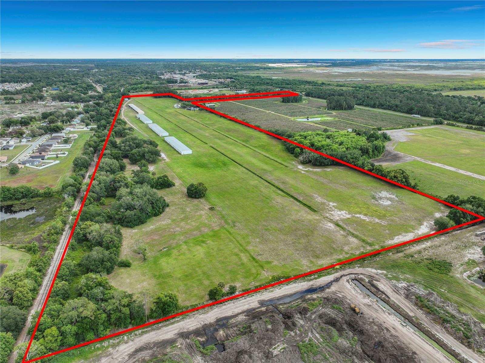 Bob White Airport represents a rare opportunity to acquire a fully operational, FAA-licensed, privately owned/public use airfield in Orange County, Florida—one of the most supply-constrained and rapidly growing regions in the state. This asset combines a 3,300-foot runway, multiple hangars, and an on-site private residence, creating a unique blend of aviation infrastructure, income potential, and lifestyle appeal. Due to increasing regulatory barriers, zoning restrictions, and land scarcity, new airport development in this region is extremely limited. As a result, existing licensed airfields such as Bob White Airport are considered irreplaceable assets with significant long-term upside potential.
FAA-Licensed private airfields in Orange County are exceptionally rare, making this a highly defensible and irreplaceable asset.
Existing income-producing hangars provide immediate revenue through aircraft storage leases, with potential to increase rents or expand capacity. There are multiple structures currently in place configured for private and tenant aircraft storage, Potential for expansion or redevelopment. The property offers development upside potential for: Additional hangar construction, Hangar condominium sales, Private airpark residential lot development. Orange County, Florida is one of the fastest-growing regions in the United States, anchored by Orlando’s tourism industry, expanding population, and business-friendly environment. The subject property benefits from proximity to major highways, business districts, and world-renowned attractions. Located within close proximity to Orlando’s major economic drivers, tourism corridors, and population growth centers. Suitable for a wide range of general aviation aircraft. The private home located on-site offers direct runway access; ideal for owner-user or on-site management. Current income streams include hangar rental income & potential tie-down/storage fees. Value-Add opportunities include increase hangar lease rates, develop additional hangar space & introduce aviation services (maintenance, fuel, etc.). Central Florida continues to experience strong inward migration, economic growth, and increased demand for private aviation infrastructure. Limited availability of private airfields has created a supply-demand imbalance, supporting long-term appreciation and income growth.