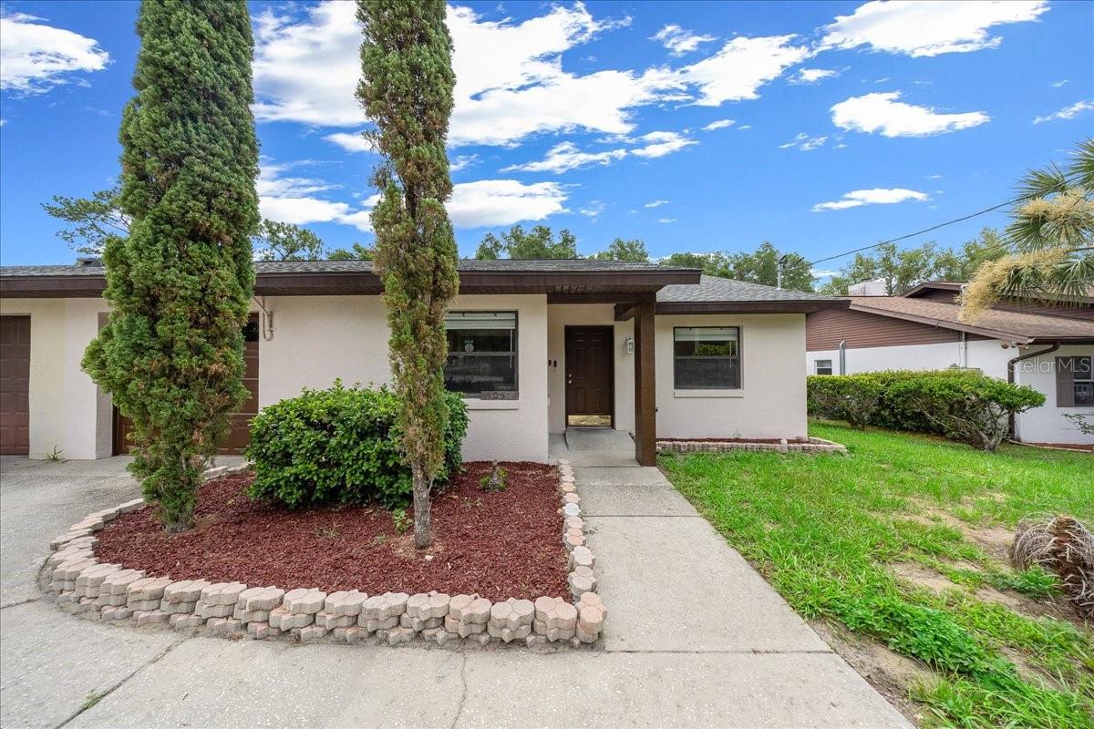 Close to Rainbow River recreation, this 3-BD/2-BA half duplex offers a 1-car garage, a fully fenced backyard and 1,380 square feet of comfortable living space! Tile flooring runs throughout the home, giving the main living areas and bedrooms a durable, easy-care finish. Sliding glass doors bring natural light into the living room and open to a screened porch overlooking the backyard. Granite countertops, stainless appliances, and a pass-through view into the dining area give the kitchen a comfortable layout. A split floor plan places the main ensuite on one side of the home, with 2 additional bedrooms and a shared bath on the opposite side. Both the main bedroom and one guest bedroom include sliders to the screened porch adding another connection to the outdoor space.  New vanities bring an updated finish to the bathrooms. Washer and dryer are located in the 1-car garage, with additional space for storage. Out back, the screened porch connects to a fully fenced yard giving kids and pets a defined outdoor area to enjoy. Located near the Rainbow River area, this home keeps tubing, boating, local dining, and everyday Dunnellon conveniences within easy reach.