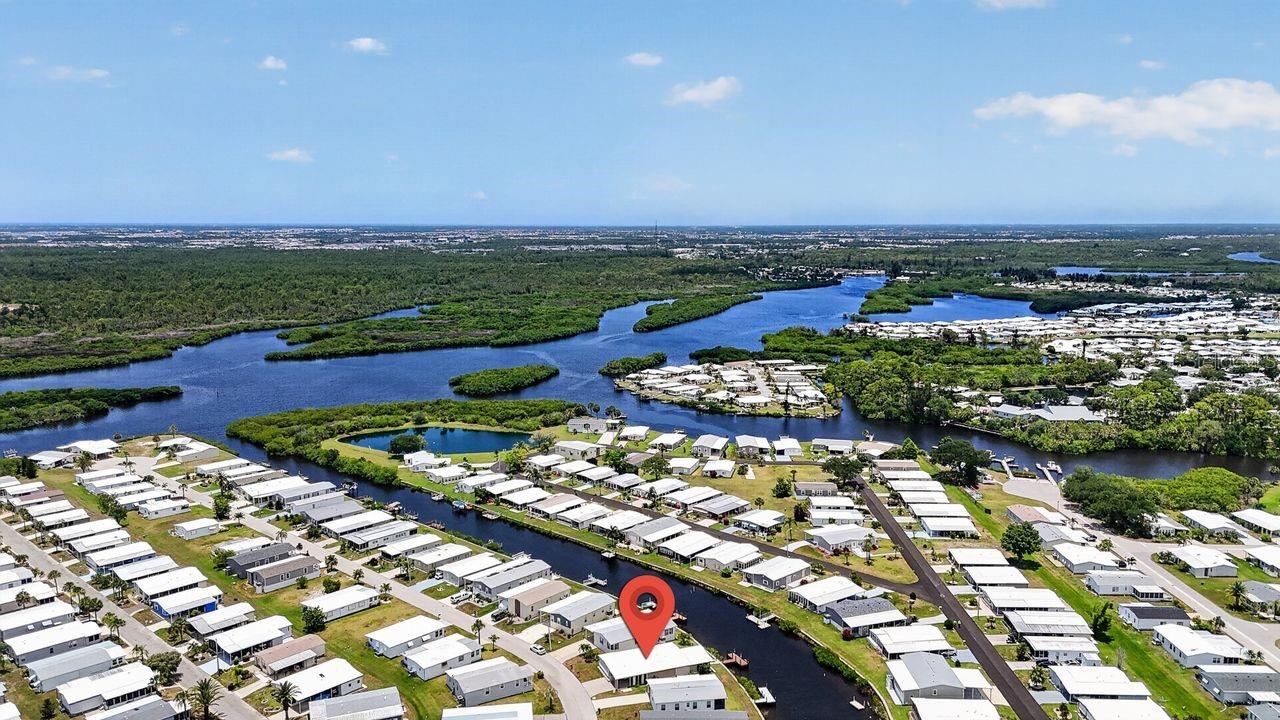 Rare canal-front 3-bedroom, 2-bath home with a private dock in Harbor Cove, a 55+ waterfront community with a low $175 monthly HOA! Enjoy excellent boating and fishing with direct access to Charlotte Harbor and the Gulf via the Myakka River from your dock, complete with water, electric service, and new composite decking. Three-bedroom homes are seldom available here, and this home offers a 1,338 sq. ft. floor plan with a spacious living room, a versatile dining or sitting area, a large air-conditioned Florida room, and a 256 sq. ft. screened lanai overlooking the canal. The updated kitchen features a large center island, abundant granite countertop prep space, stainless steel appliances, and ample wood cabinetry (2023). Five mini-split A/C units installed in 2024 let you cool individual living areas as needed for added comfort and efficiency. Major updates include the roof, windows, siding, vapor barrier, interior walls and paneling, flooring and some subflooring, and the updated hall bathroom. Designed to make the most of waterfront living, the home offers multiple places to relax and entertain, from the Florida room and screened lanai to the epoxy-coated patio and private dock just steps from your back door. Peaceful canal views, spectacular sunsets, and an ever-changing backdrop of birds, fish, and other Florida wildlife make this outdoor living space truly special. The oversized covered carport accommodates two to three vehicles, keeping them protected from the Florida sun, while two storage sheds provide a laundry area, workshop, and additional storage. The home is being sold partially furnished, offering added convenience for seasonal or year-round living. Harbor Cove's amenities include a 17,000-square-foot waterfront clubhouse with views over the 90-slip marina, two swimming pools, hot tub, fitness room, library, billiards, tennis, pickleball, bocce, shuffleboard, and a full calendar of social events and activities. Conveniently located near Gulf beaches, golf courses, shopping, dining, farmers markets, and I-75 for easy access to area airports. If you've been waiting for a waterfront home with a private dock, you won't want to miss this one. Schedule your private showing today!