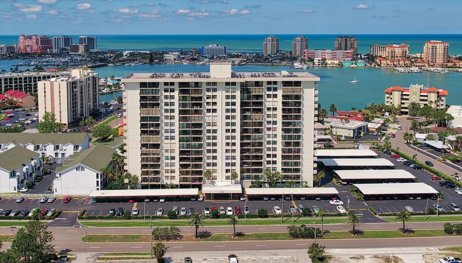 This spectacular unit has stunning high & expansive views! Step into your dream coastal retreat with this newly renovated, 2-bedroom, 2-bathroom unit on the 9th floor. Boasting a spacious balcony that offers the most desirable west and gulf views, complete with sunsets!! The newly added impact sliding doors enhance the panoramic vistas, creating a seamless indoor-outdoor living experience. The bright kitchen with stone countertops and an additional island is perfect for entertaining. Remote controlled shades, updated electric panel, in-unit laundry closet, uniquely hidden pull out ironing board, well-appointed primary bedroom walk-in closet system and luxury vinyl throughout were added for convenient living. This condo's built in storage systems maximize all use of space to provide a seamless living space. HVAC & water heater 2021 & all new water lines/plumbing. The building offers a workout room, dry sauna, billiards, storage, resort style heated pool/spa, outdoor grill area and spaces for community gatherings. Next to Publix grocery store, local shops, restaurants, and a short distance to the beautiful Clearwater Beach! This home is a true gem in paradise. Live the luxury lifestyle that Coastal Classic Design offers. Covered parking space #56 conveys with unit