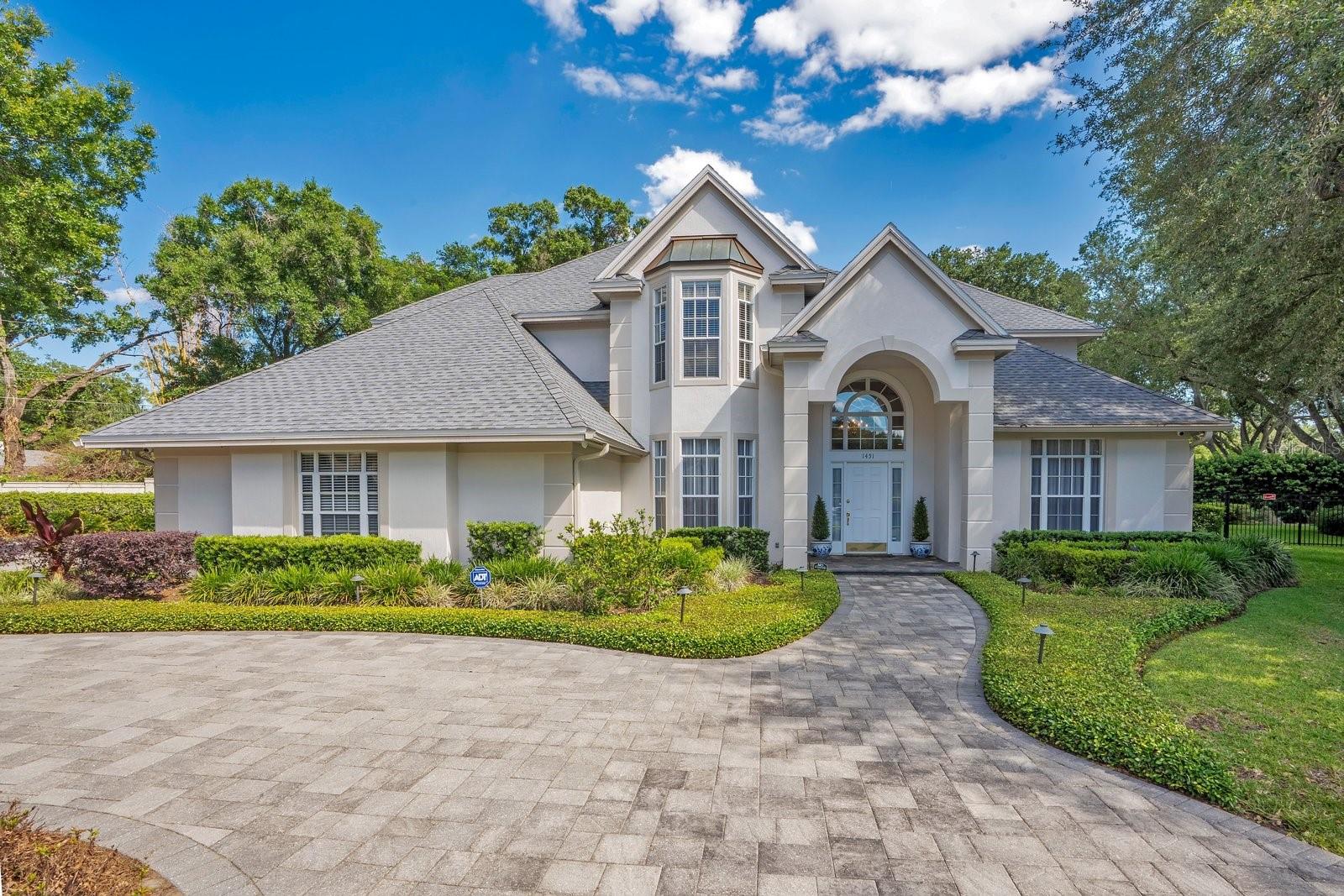 Situated at the end of a private cul-de-sac within Lakeland’s most coveted enclave of Lake Hollingsworth, this stately residence offers a rare blend of architectural pedigree and secluded tranquility. Custom-built by Strawbridge in 1994 and maintained by a single owner with meticulous care, the property spans nearly 3,900 square feet of sophisticated living space on an expansive, near 3/4-acre lot. This home boasts natural light throughout, highlighting the fine finishes and thoughtful design, while a block wall surround at the rear of the property ensures both heightened security and lasting seclusion.

The interior layout is a masterpiece of functional elegance, specifically designed for those who value both productivity and leisure. The floor plan features two distinct workspaces, including a private library that leads into a secluded downstairs executive office, creating a sophisticated environment for a professional retreat. For the consummate host, the gathering room features a fully equipped wet bar, while a dedicated wine cellar is conveniently located off the kitchen, ensuring effortless service for grand-scale entertaining.

An epicurean kitchen is outfitted with premium appliances and serves as the central heart of the residence, while four spacious bedrooms and 3.5 bathrooms provide ample accommodations. The upstairs primary suite acts as a secluded sanctuary, offering elevated views of the pristine grounds. Outside, the large lanai features a built-in grill and an extended, screened-in pavered area, providing a seamless transition to an outdoor oasis surrounded by lush greenery. Practicality meets luxury with a side-entry 3-car garage, featuring a circular drive for ample guest parking and additional oversized parking space just outside the garage entry. Schedule your private viewing today to experience this one-of-a-kind property.
