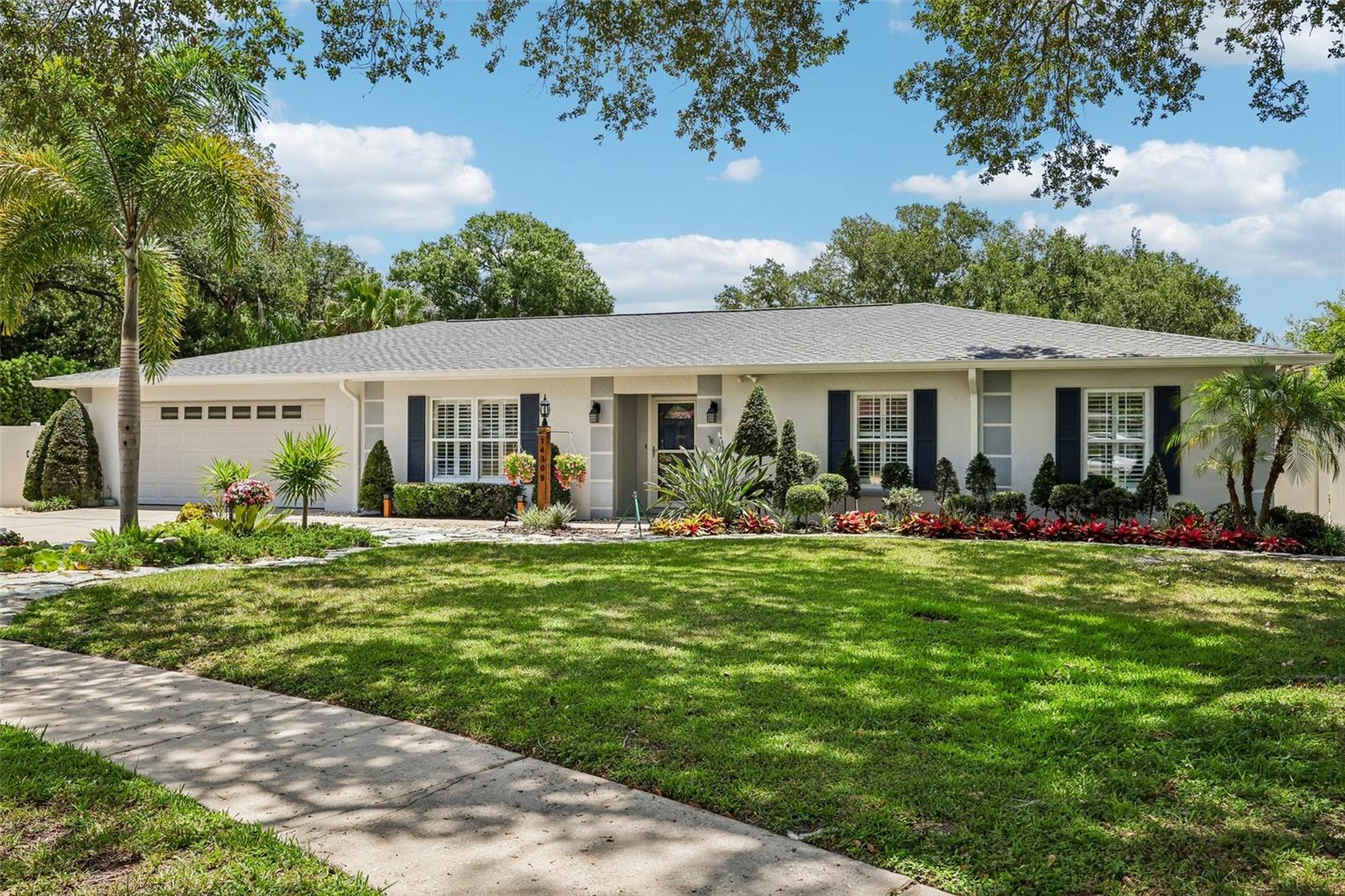 Welcome to your beautiful new home at 14309 Brentwood Drive! Nestled perfectly within the highly sought-after Brentwood subdivision, this property sits on what is easily one of the largest and nicest lots in the entire area. As you pull up, you'll immediately notice the fresh exterior paint and the lush, vibrant lawn, which features brand-new sod laid in 2025 and a completely new irrigation system installed throughout the property.  The massive, beautifully manicured yard is fully enclosed with a durable PVC fence, offering you the ultimate private retreat.  We've even replaced all the outdoor faucets with high-quality brass fixtures for longevity.   Step inside and out of the Florida heat where you will be greeted by ice cold air courtesy of the brand new HVAC system! When you're ready to relax, a stunning new French door leads you right out to an incredible enclosed lanai. Completely upgraded in 2025, this space features real glass windows and its very own mini-split AC unit, turning it into a comfortable, year-round sunroom regardless of the Florida weather. Step inside, and you'll find that the upgrades just keep coming. The entire home feels light and bright thanks to fresh interior paint, elegant vinyl plantation shutters on every window, and brand-new ceiling fans to keep the breeze flowing. The kitchen is fully prepped for your next dinner party, boasting a gorgeous new backsplash, a brand-new sink, and all-new appliances, including a modern refrigerator, microwave, and stove. Down the hall, the guest experience is elevated with a beautifully remodeled hall bath. Even the bedrooms received special attention, featuring custom closet shelving to keep your wardrobe perfectly organized. While the cosmetic updates are stunning, the true value of this home lies in the big-ticket mechanical upgrades that you rarely find all in one place. You can rest easy knowing the roof was just replaced in 2024. The home was fully re-piped in 2023, and in 2025, a new tankless water heater was added so you will never run out of hot water. On the electrical side, the breaker box has been completely rewired for greater capacity, and a whole-home electrical surge protector has been installed to keep all your devices safe. Every single detail has been thoughtfully managed so you can simply unpack and start living.
