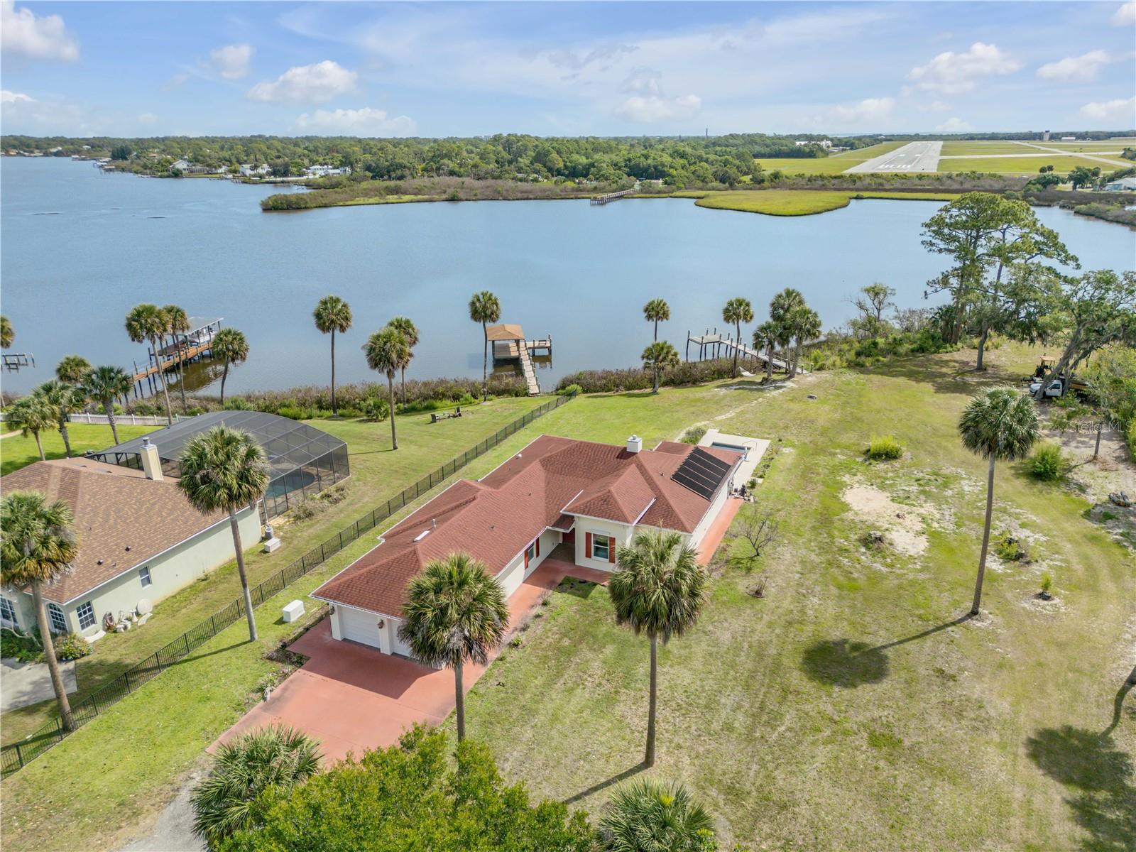 Direct Intracoastal access waterfront 3-bedroom, 3.5-bath, 1.25 acre property on Turnbull Bay.  It offers a private dock, screened in private pool, and beautiful bay views. Built in 2018, this single-story home features 2,586 square feet of heated living space and an attached 2-car garage. The home offers an open floorplan with high ceilings, a split-bedroom layout, a primary bedroom on the main floor, inside laundry, and a spacious waterfront kitchen that opens to the main living areas. Get your popcorn! There is a screened in private theatre room, making it ideal for everyday living and entertaining. Exterior features include an in-ground pool, screened in patio area, mature landscaping, and direct waterfront dock access to enjoy waterfront boating, kayaking and fishing. No HOA.