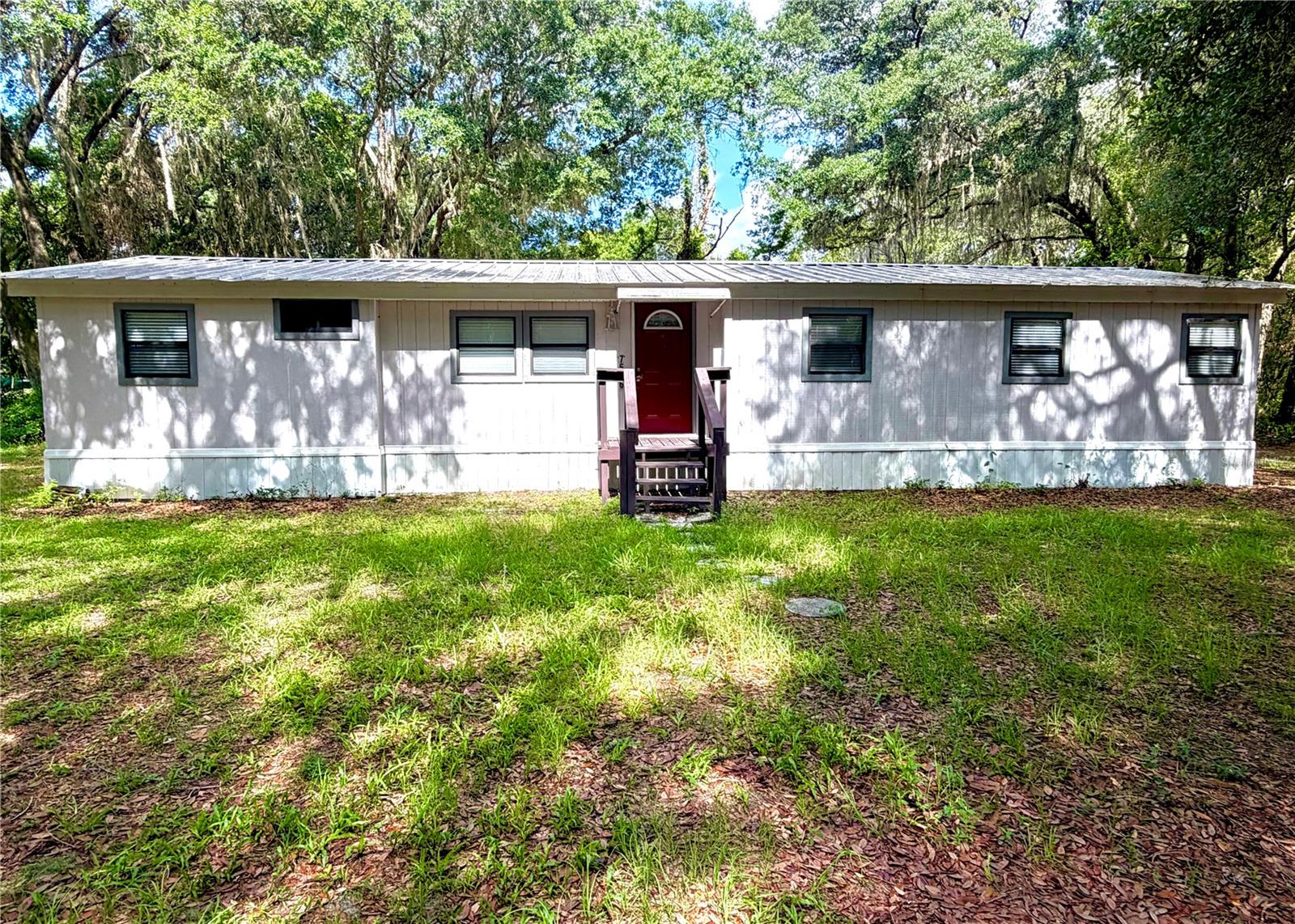 This 3-bedroom, 2-bathroom double-wide home offers a spacious 1,423 square foot layout on a cleared 1.01-acre lot. Featuring high ceilings, vinyl flooring, large laundry room, eat in kitchen, bonus room for an office, double primary bedroom and a Florida room for extra living space so as the interior provides a comfortable and modern feel. The exterior is built for durability with HardiPlank type siding and a metal roof. The lot features a large barn style shed that could be finished into a guest house, art studio, music room, etc. Property has citrus trees, mature grape vines, large live oaks for plenty of shade. 
Just minutes to 6000 acre Santa Fe with 4 public boat ramps and parks. Home is Located in Lake Bonnet Estates, you are in the heart of Florida's lake country, surrounded by numerous recreational lakes for boating, fishing, and outdoor enjoyment  Enjoy over an acre of cleared, wire-fenced land with no HOA fees or restrictions.
This property is perfectly situated in Melrose, offering a convenient commute between the city amenities of Gainesville and the historic charm of Palatka.