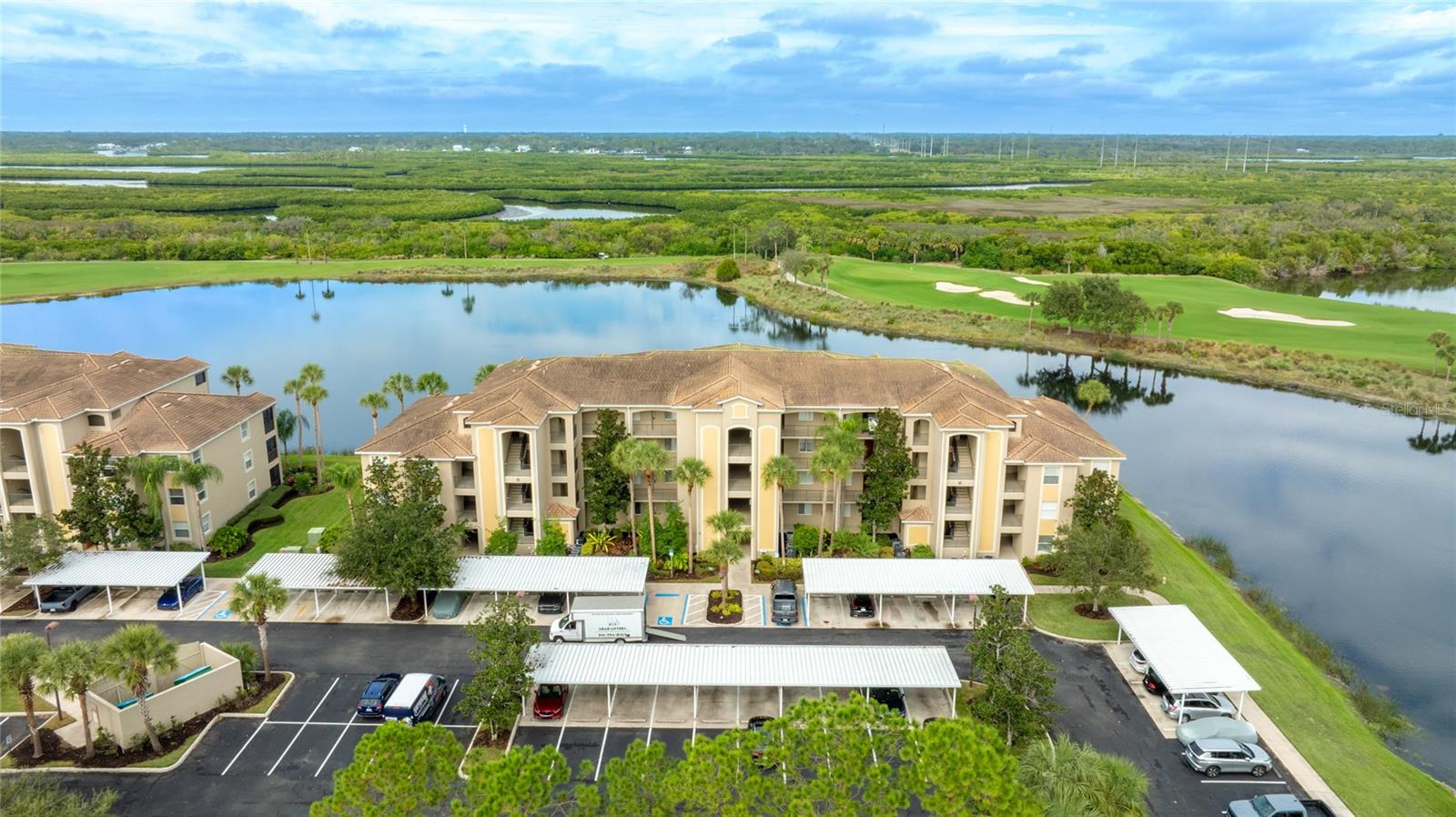 Your Premier River Strand Golf & Country Club Lifestyle Awaits! Welcome to this absolutely stunning, move-in-ready, TURNKEY (all furnishings included!) ground-floor condo, perfectly positioned to offer gorgeous, unobstructed water views that you can enjoy every day. This open-concept sanctuary is flooded with natural light thanks to a magnificent wall of windows, immediately welcoming you to the best of Florida living.

Inside, you'll find elegant tile flooring throughout the main living areas and a beautifully appointed kitchen featuring stainless steel appliances. The spacious owner’s retreat is a private haven, complete with an en suite bathroom and dual, generously sized walk-in closets. An additional well-sized guest bedroom ensures comfort for visitors. Step out onto your screened-in, covered lanai—it's the ideal, peaceful spot for relaxing or entertaining while taking in the scenic natural surroundings.

The value proposition here is truly exceptional: this unit includes a deeded, full golf membership! You gain immediate access to the River Strand Golf & Country Club, home to the challenging 27-hole Arthur Hills–designed championship golf course. 

River Strand is renowned for its vibrant, active community atmosphere and abundant outdoor and lifestyle amenities

Exceptional Community Amenities: The Clubhouse: A spectacular 39,000-sq-ft facility featuring a semi-formal dining area, Grille room, and a fully stocked on-site bar and restaurant.

Golf & Racquet Sports: Beyond the course, enjoy a Golf Pro Shop with the latest technology, certified teaching professionals, a Racquet Sports Pro Shop, 9 Har-Tru clay tennis courts, and newly installed pickleball courts. Racquet services, including lessons and re-stringing, are available!

Pools & Fitness: Choose from two resort-style pools (one at the Clubhouse and one at the Community Center), two heated spas, a resistance pool, and six satellite pools throughout the community. Stay active with two fully equipped fitness centers, an aerobics room, and half-court basketball courts.

Social Life: The community thrives with frequent social gatherings and events, including live entertainment throughout the year, holiday parties, trivia nights, Name That Tune competitions, pool parties, plus activities like Bridge, Mah Jong, and Bingo. Don't forget the popular Tiki Bar!

This property represents an exceptional value for River Strand living. Everything you could ever want for a luxury, active, and social lifestyle is right here waiting for you!