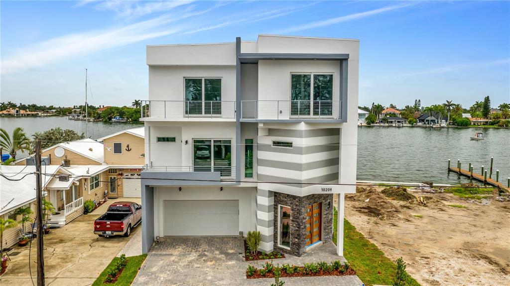 NEW BUILD AVAILABLE NOW! Situated on the deep water of Boca Ciega Bay on Treasure Island, Fl. This brand new 4,100 square feet home with elevator is fully customized to make living on the best white sand beach in the country a magical and deeply satisfying experience. With the new dock, putting your favorite vessel in the water is simple and easy. The newly built seawall ensures your view and access to the water, as well as the lifestyle that accompanies it, is protected. Built in a sleek and modern architectural style. The spacious open floor plan lends itself to entertaining. With its abundance of windows throughout, you'll enjoy unparalleled views and a bright airness inside. Floor-to-ceiling windows also allow you to look out to the sun decks and pool. When you aren't out on the water or enjoying the wide white sand beach, this area is perfect for hosting guests. A four car attached garage provides you with plenty of space to keep your vehicles protected. There is also plenty of room for you to organize your water gear neatly, so it is always ready when you are! Call today for more info on this brand new build.
--