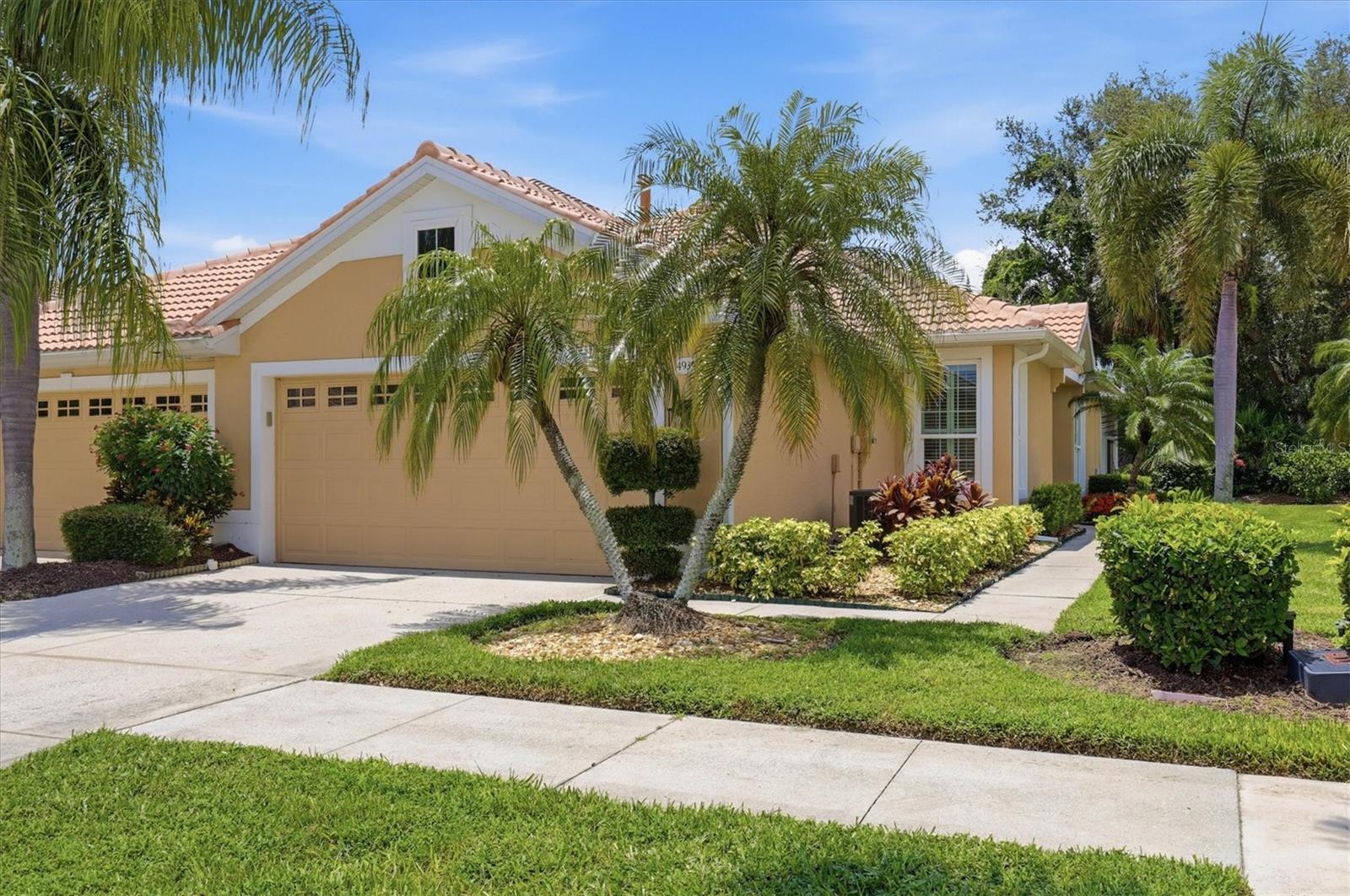 HERON CREEK GOLF & COUNTRY CLUB | 2 BEDROOM | 2 BATH | 2 CAR GARAGE MAINTENANCE-FREE VILLA Priced perfectly and packed with updates, this beautifully maintained villa delivers peace of mind, easy living, and tropical charm! Major improvements include a NEW TILE ROOF (2025), NEW NATURAL GAS WATER HEATER (2025), New South impact hurricane windows, Storm Smart roll-down screens on the extended lanai, upgraded attic insulation for enhanced energy efficiency, and updated stainless steel appliances. A graceful cluster of triple palms swaying in the Florida breeze welcomes you home, setting the tone for the relaxed Florida lifestyle that awaits. Inside, a fresh and airy coastal interior dressed in soothing shades of blue showcases beautiful bamboo-toned engineered hardwood flooring, timeless plantation shutters, and an open living and dining area designed for comfortable everyday living and entertaining. The well-appointed kitchen features rich granite countertops, convenient pull-out shelving, a spacious pantry, breakfast bar, sunny dinette, and natural gas availability for discerning chefs. The spacious primary suite serves as a peaceful retreat, offering tranquil views of the lush landscaped privacy buffer and featuring dual closets and an ensuite bath with dual vanities. Thanks to the combination of impact windows, added insulation, and thoughtful upgrades, the home enjoys an exceptionally quiet and comfortable interior atmosphere. The redesigned guest bedroom has been expanded to an impressive 12' x 15' and offers exceptional flexibility as a guest suite, office, or hobby room. Outside, colorful tropical landscaping, vibrant ixoras, blooming pink crepe myrtles, a private landscaped greenbelt backdrop, and the extended screened lanai create the perfect setting for morning coffee or evening cocktails. Ideally situated within the community, you'll enjoy a short golf cart ride to the clubhouse, golf facilities, resort pool, fitness center, tennis courts, dining venues, and all the amenities that make Heron Creek so special, while nearby resident gates provide quick access to shopping, restaurants, medical facilities, and everyday conveniences. Whether you're searching for a year-round residence, seasonal retreat, or income-producing winter getaway, this move-in-ready villa checks all the boxes. Enjoy the Heron Creek lifestyle featuring 27 holes of championship Arthur Hills golf, a 21,000-square-foot clubhouse, resort-style amenities, exceptional dining, and a vibrant social calendar. Beautifully updated, impeccably maintained, storm-ready, and perfectly positioned—this is Florida living at its easiest and best. Welcome to Villa Blue Skies, where every day feels a little lighter, brighter, and more relaxed.
